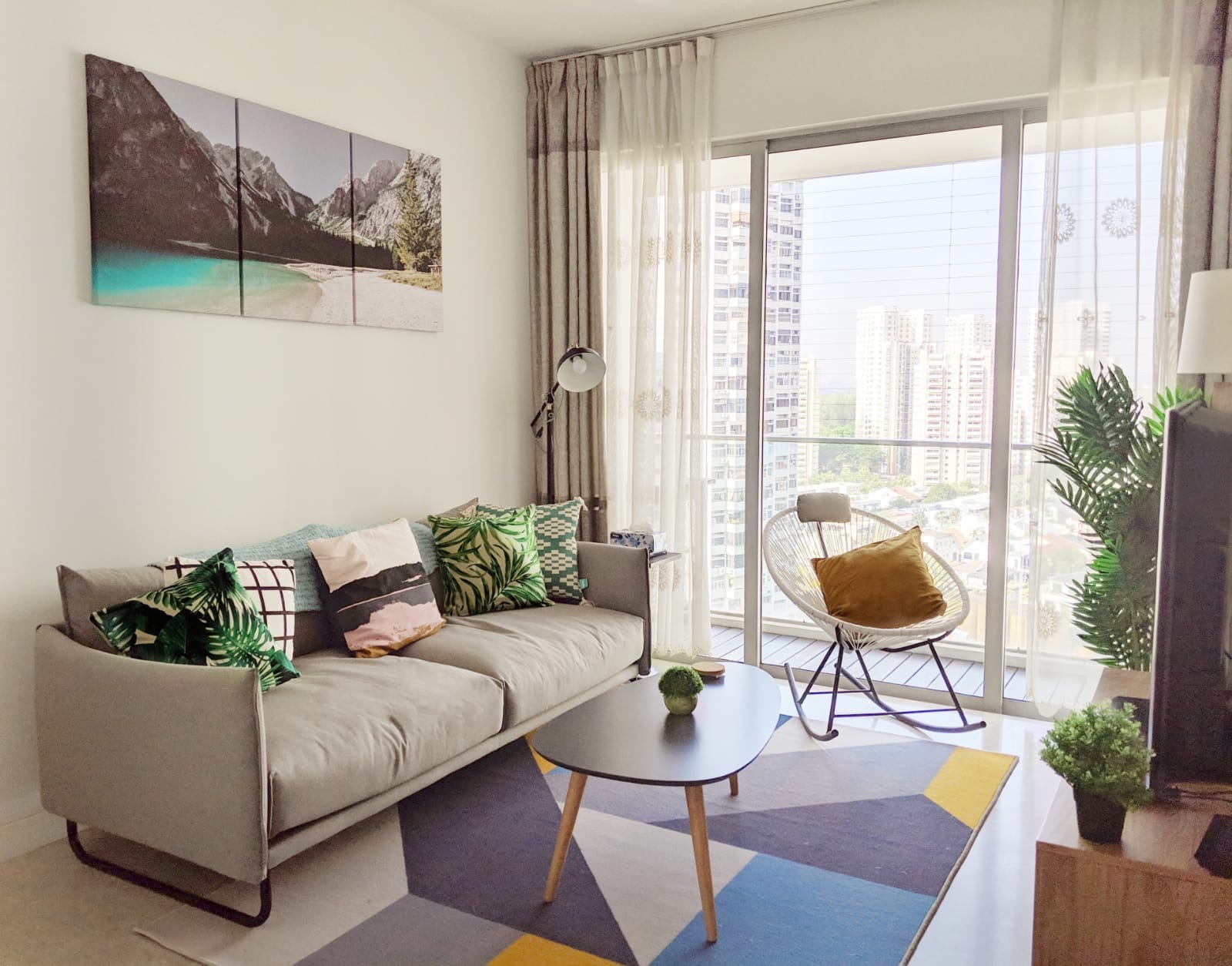 Urban Jungle Haven - Modern living room with beige sectional sofa, green and white patterned pillows, abstract painting on