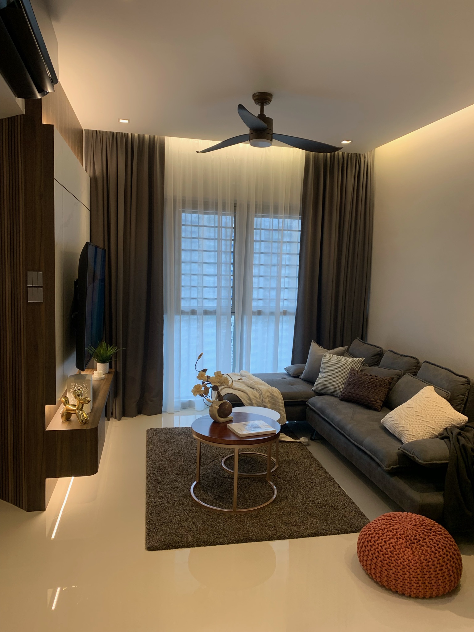 Modern Day Resort-styled Living Room - Modern living room with large windows, sheer curtains, wooden entertainment unit, gold