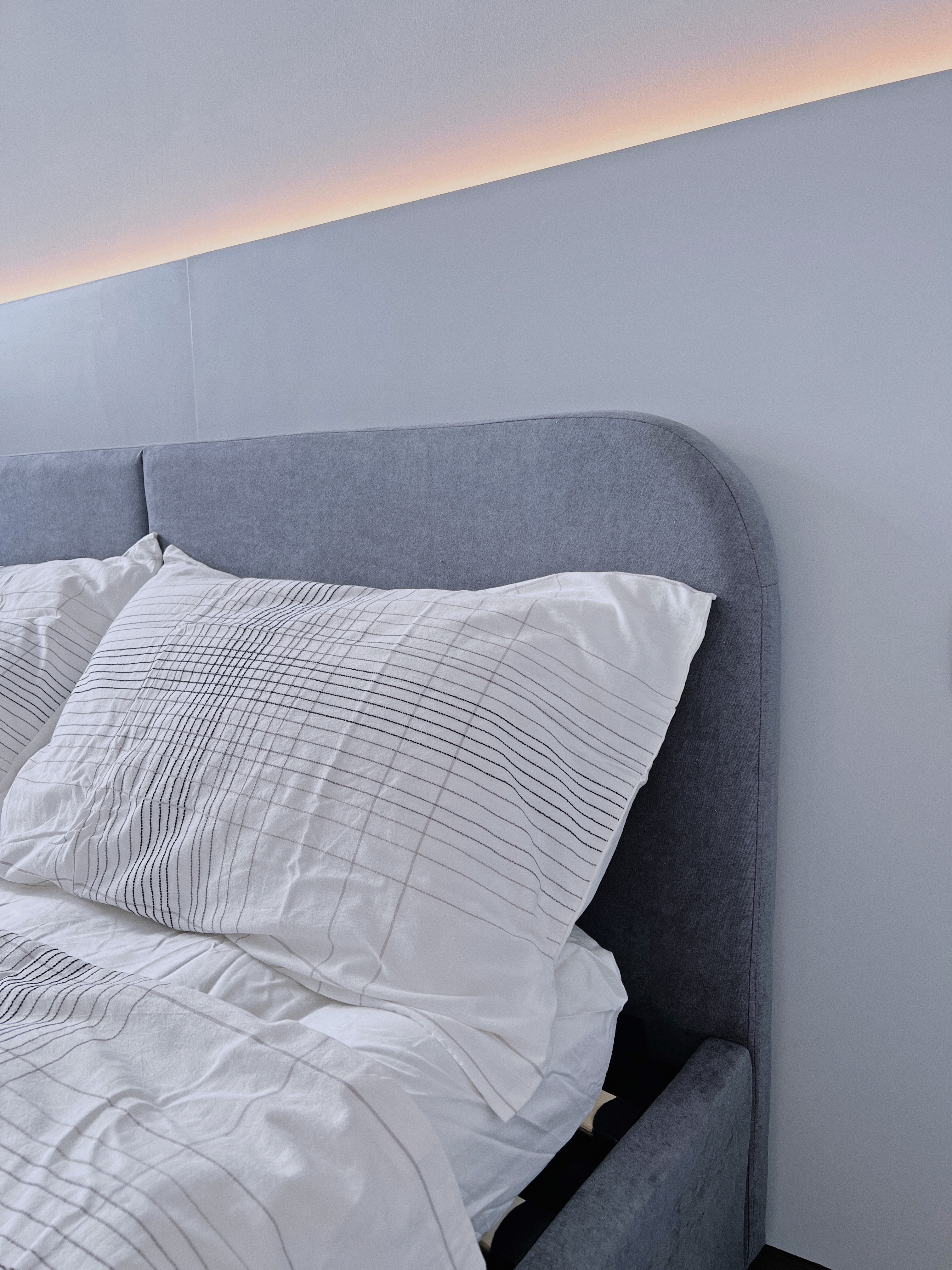 Spacious & Functional Master Bedroom  - Grey upholstered headboard, white and black striped bedding, modern minimalist