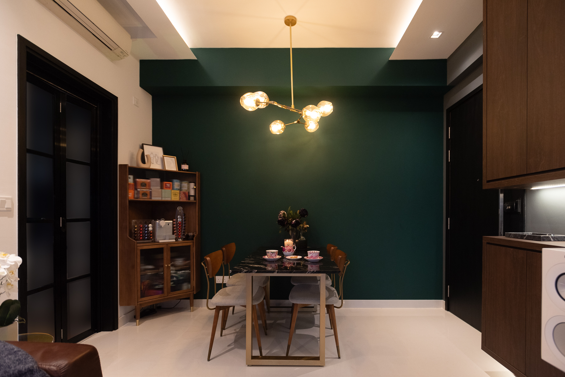 Unconventional colour scheme for our Mid-Century Modern space - Modern dining room with dark green accent wall, sleek black