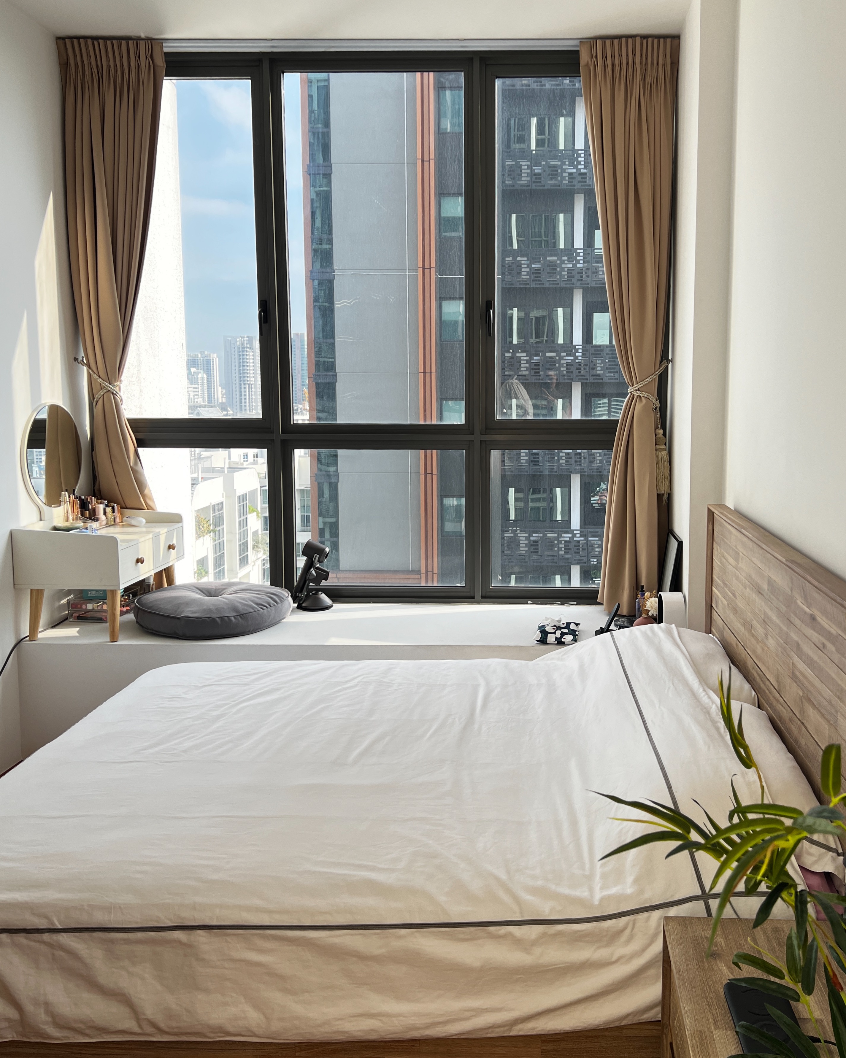 Bright & Sunny Cosy Corner - Large window, beige curtains, cityscape view, modern bedroom, white bedspread, wooden headboard