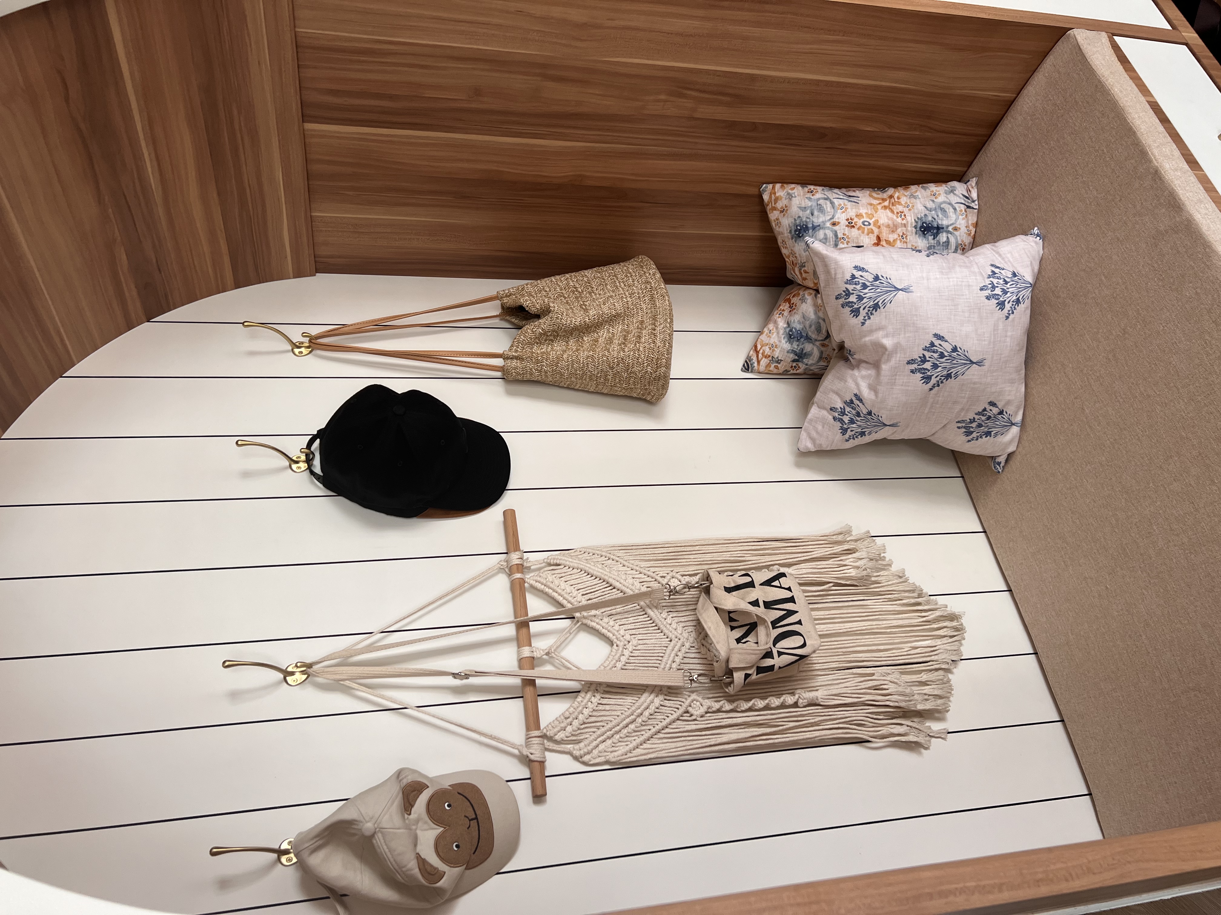 Transform Your Entryway: Double up as a Cosy Corner - Wooden headboard, beige woven bag, floral patterned pillow, black hat