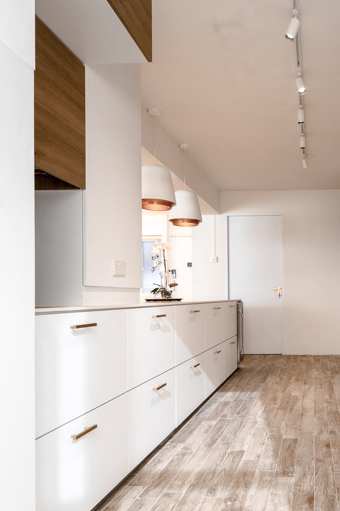 Creating a private dining kitchen space at home - White kitchen cabinetry, wooden accents, modern pendant lights, light wood