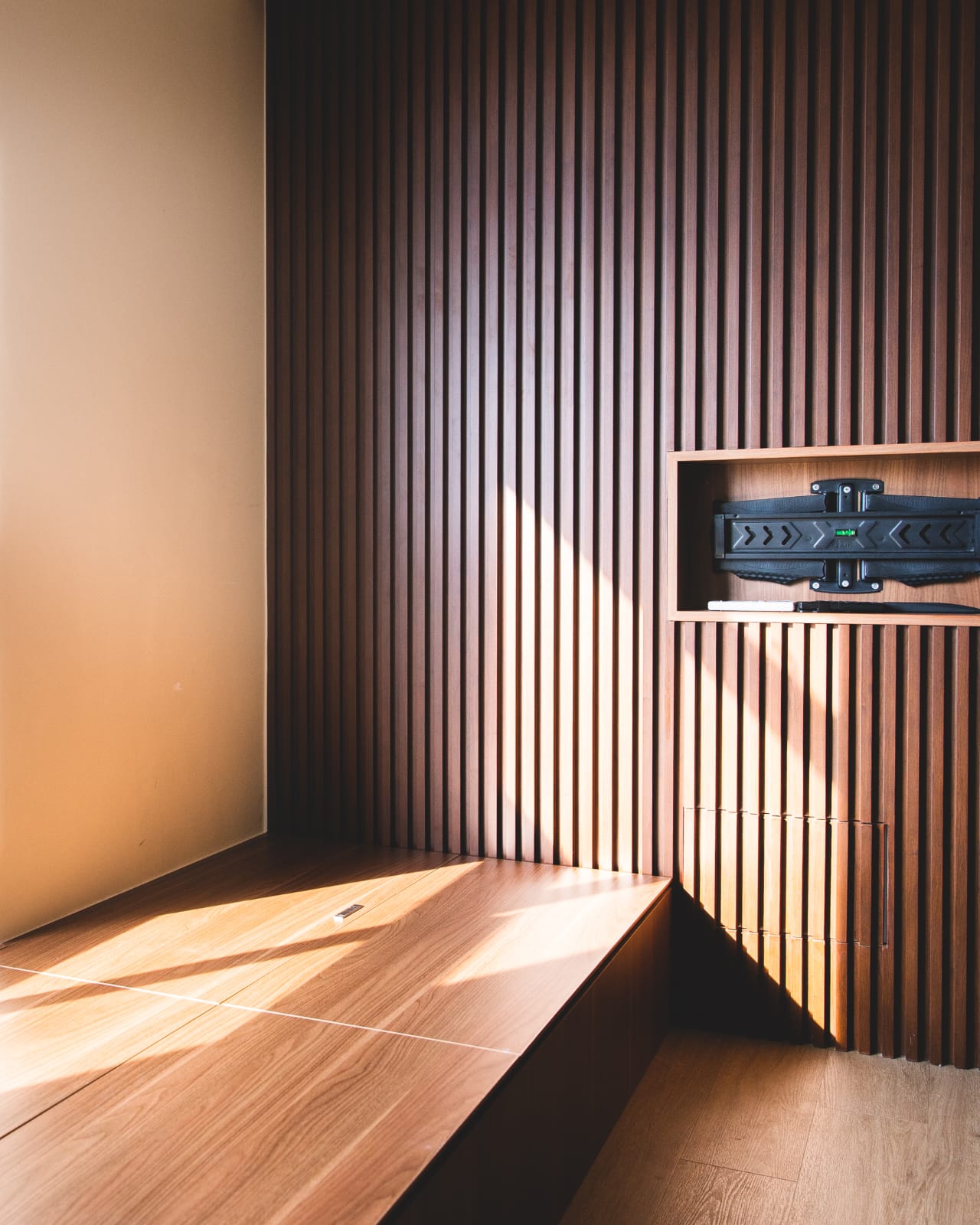 A work in progress: living alone - Wooden wall with vertical slats, sunlight streaming through, wooden floor, modern shelving