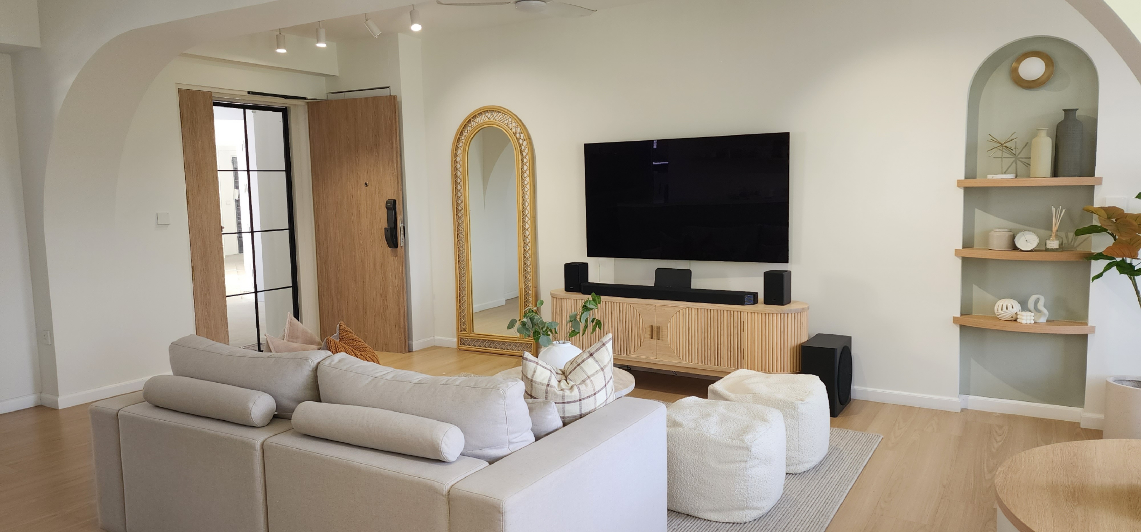 Curves & more - Modern living room with beige sectional sofa, wooden coffee table, and soft cushions. Minimalist decor