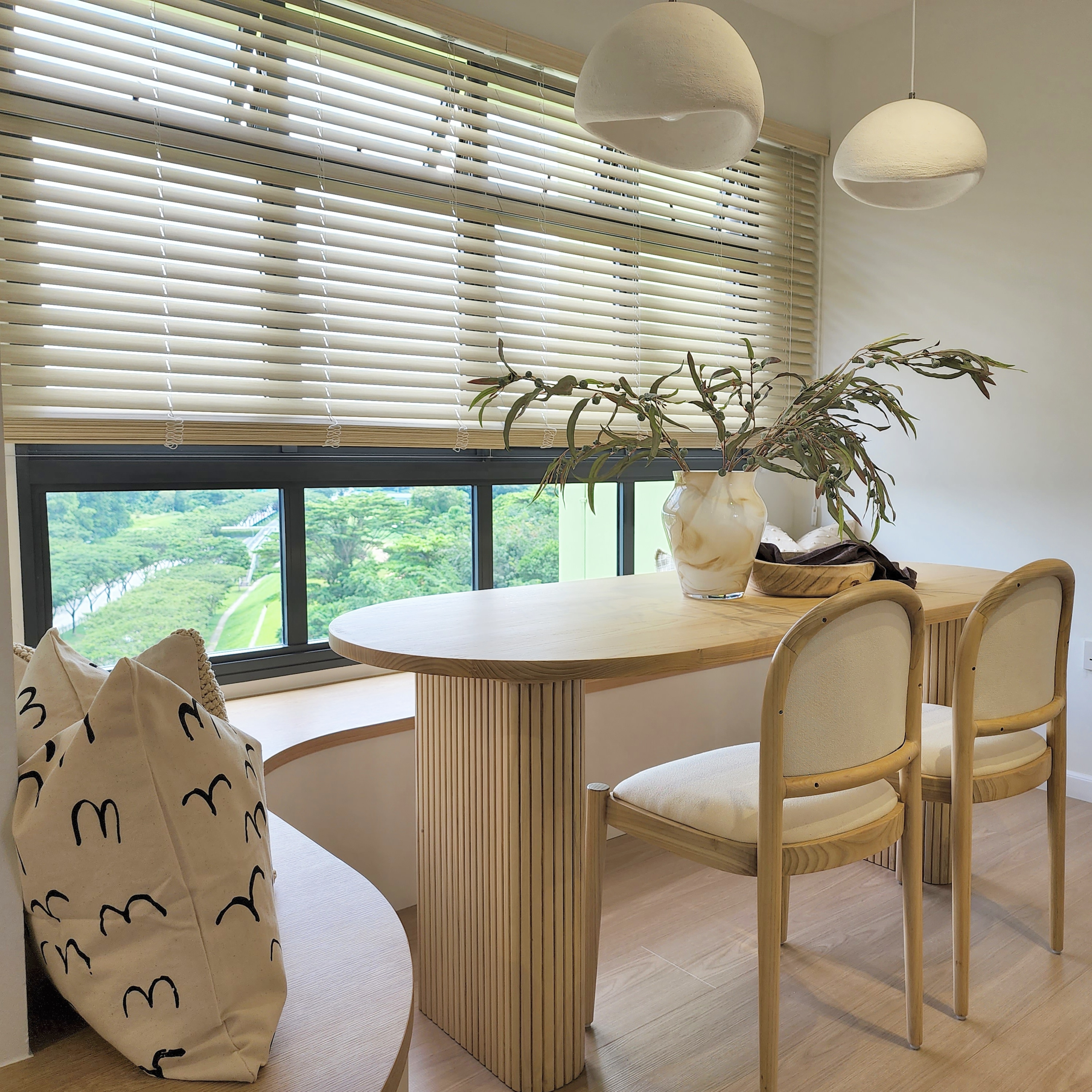Curves & more - Modern dining room with large windows, beige and white color scheme, wooden furniture, round wooden table