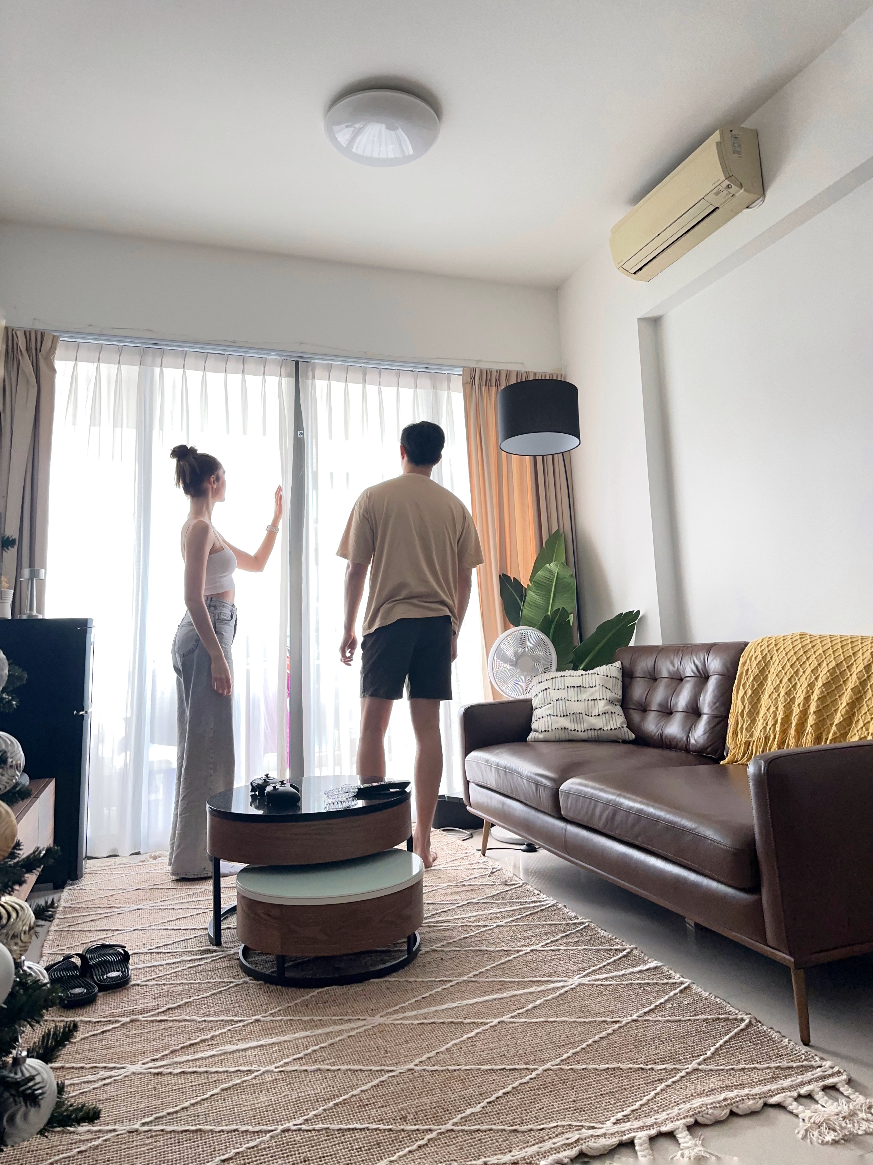 Welcome To Our Mid-Century Modern Condominium - Bright room with large windows, beige ceiling fan, woman in white tank top