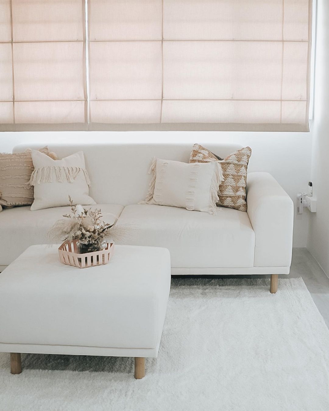 The home of a happy family of five - Cream-colored sofa, beige and brown throw pillows, minimalist decor, soft natural light