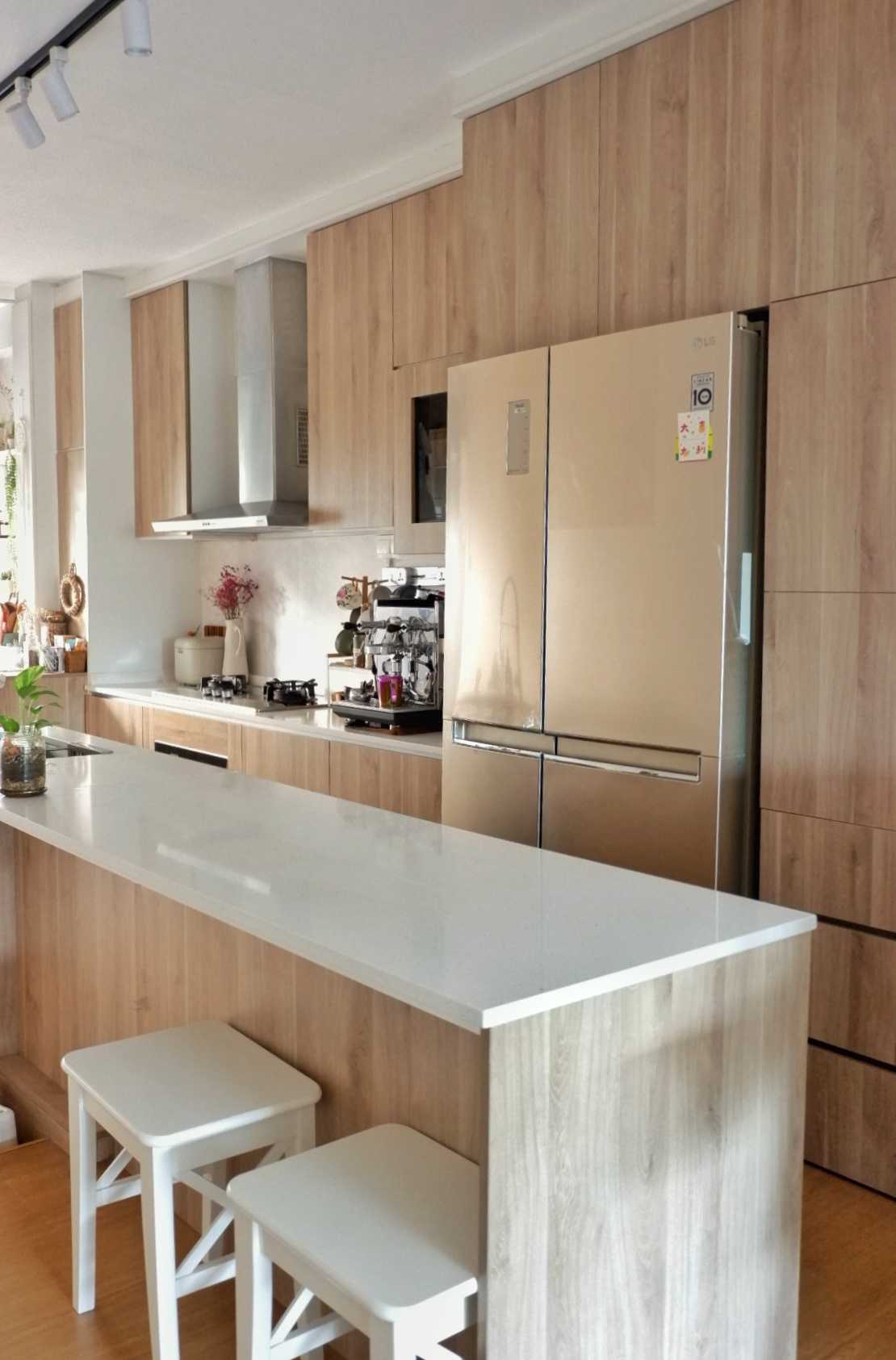 Elegant Beach Resort Inspired Kitchen - Wooden kitchen cabinetry, stainless steel refrigerator, modern design, light wood