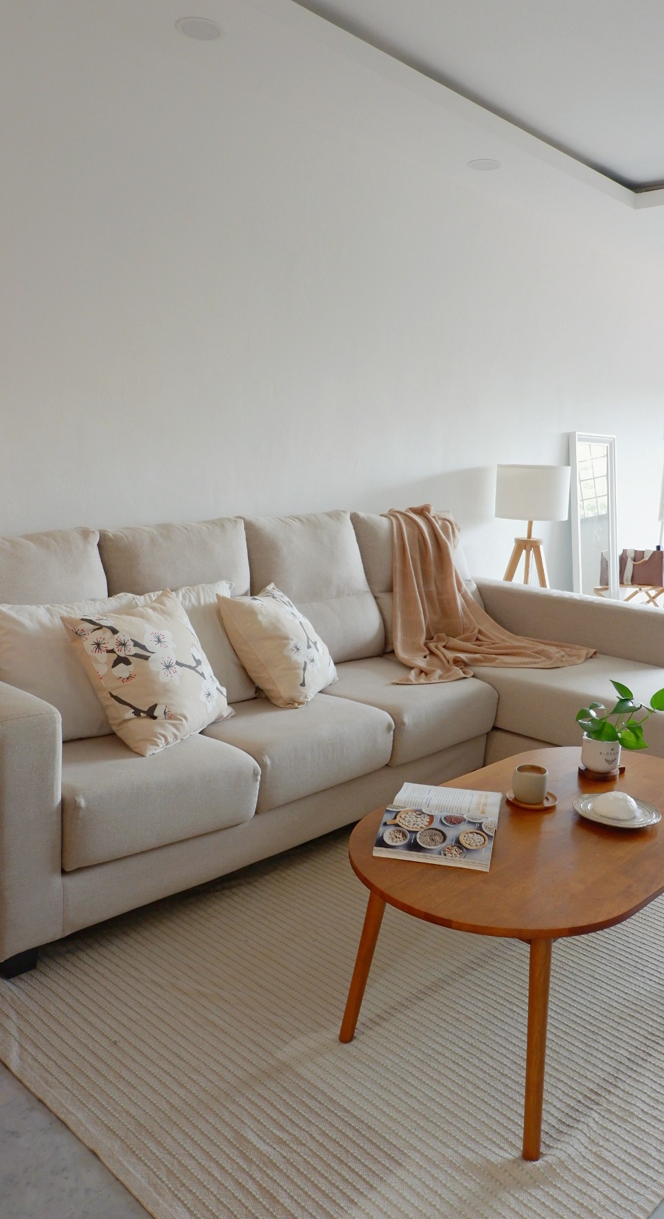 Scandinavian themed Living Room - Cream-colored sectional sofa, beige throw pillows, floral pattern, cozy living room