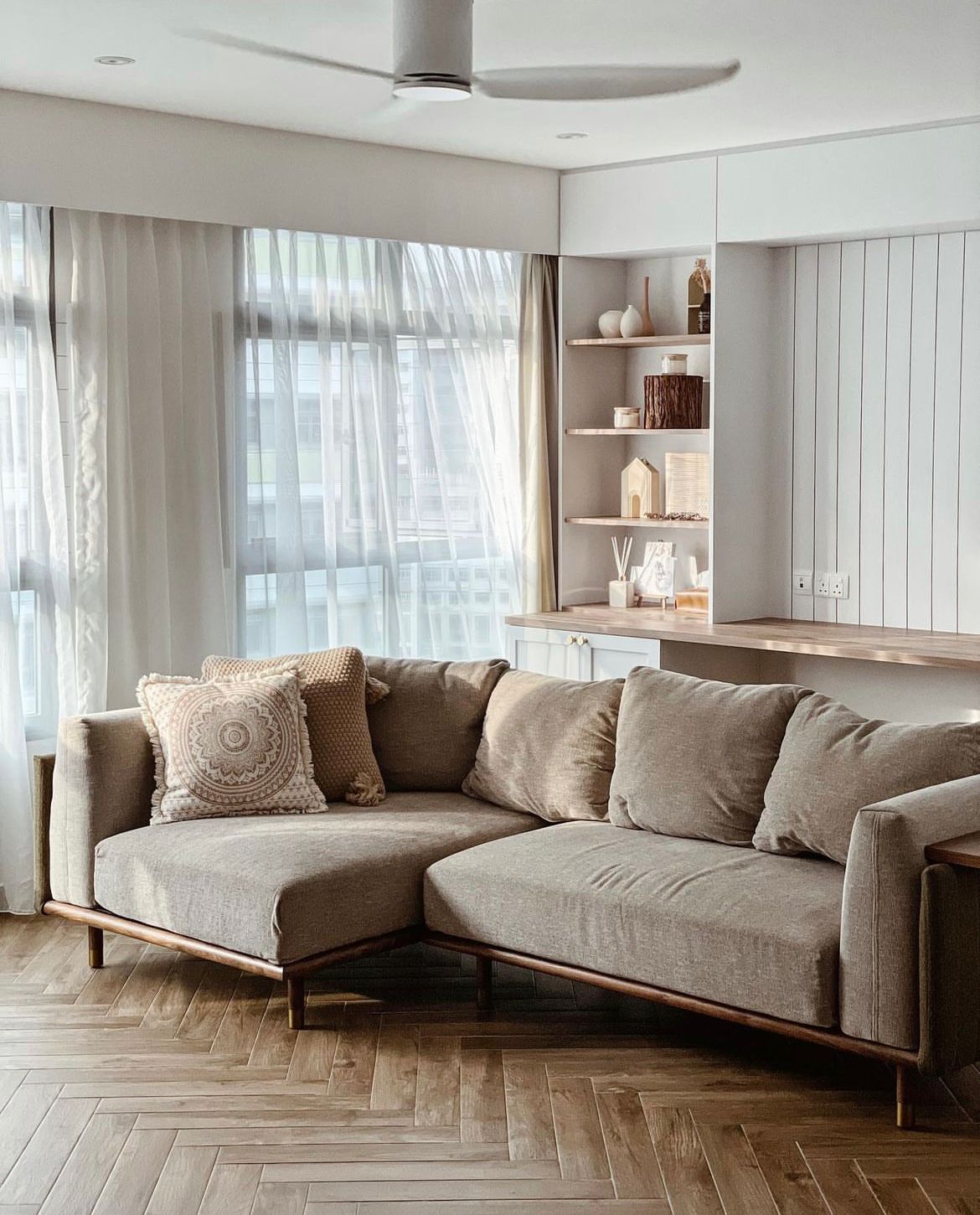 Living room with minimal but not-so-simple decor  - Modern living room, cozy seating, beige sofa, wooden legs, herringbone