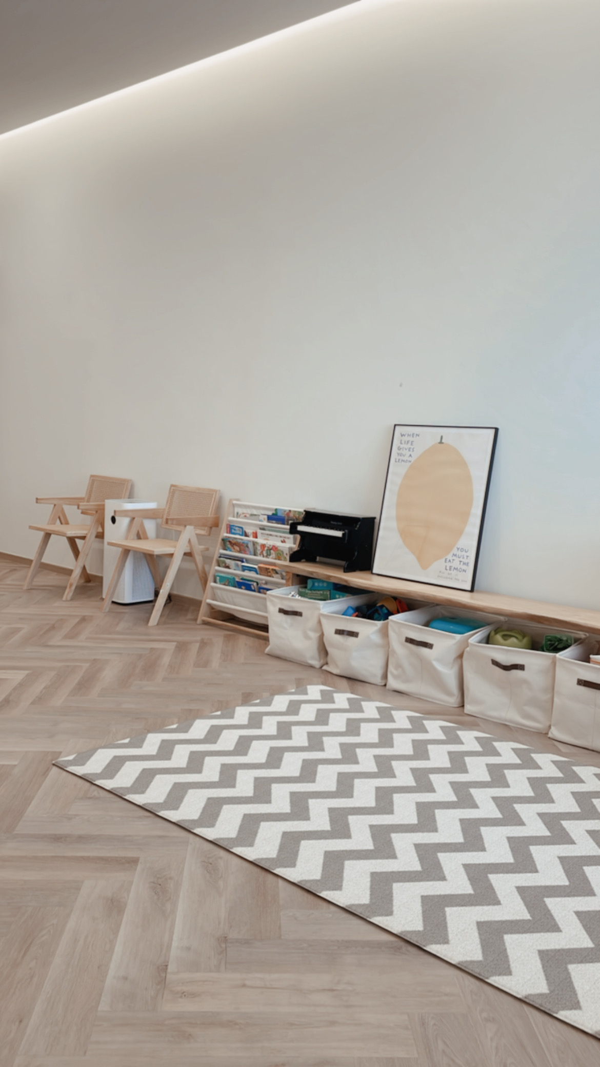 Functional Japandi living room - Wooden floor, herringbone pattern, light-colored walls, minimalist decor, wooden chairs