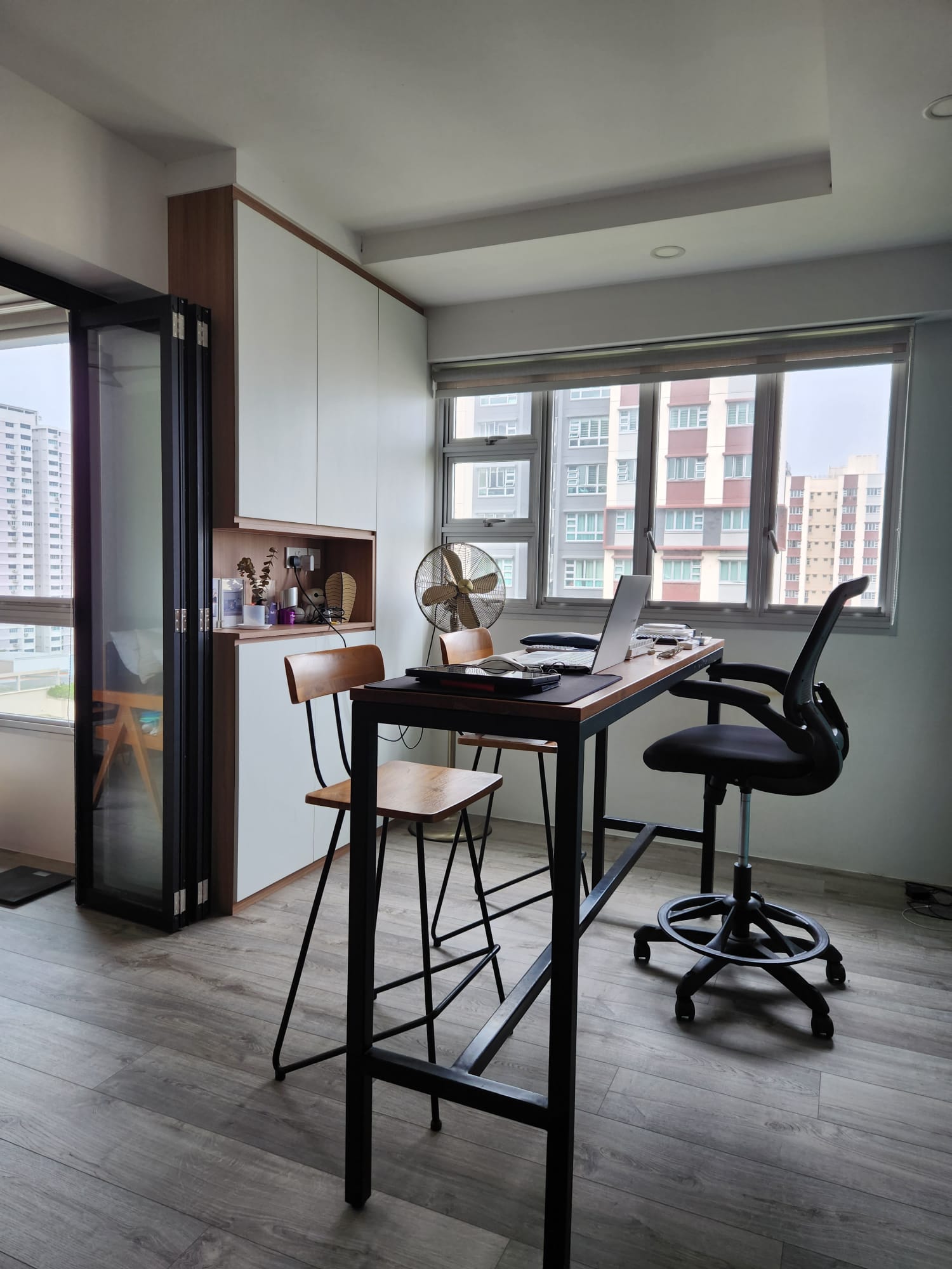 A versatile, multi-purpose home office - study space - Modern workspace with sleek black desk and wooden chairs, large window