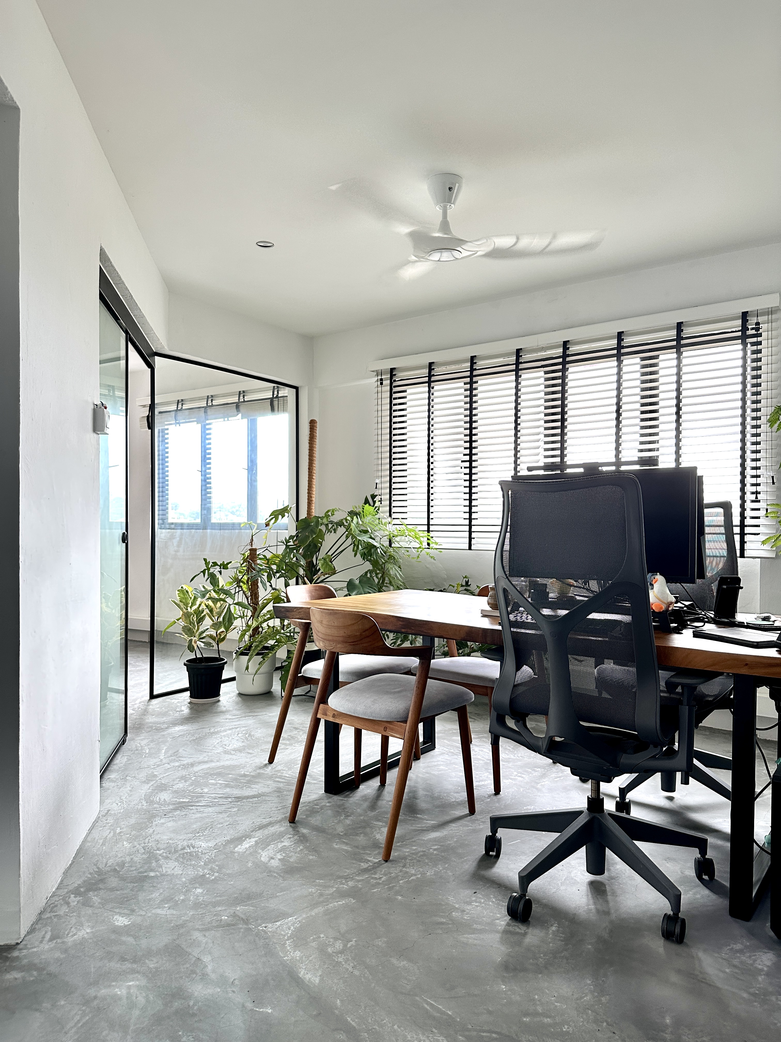 Combine dining & working space - Modern minimalist office space, sleek wooden desk, black mesh office chair, large windows