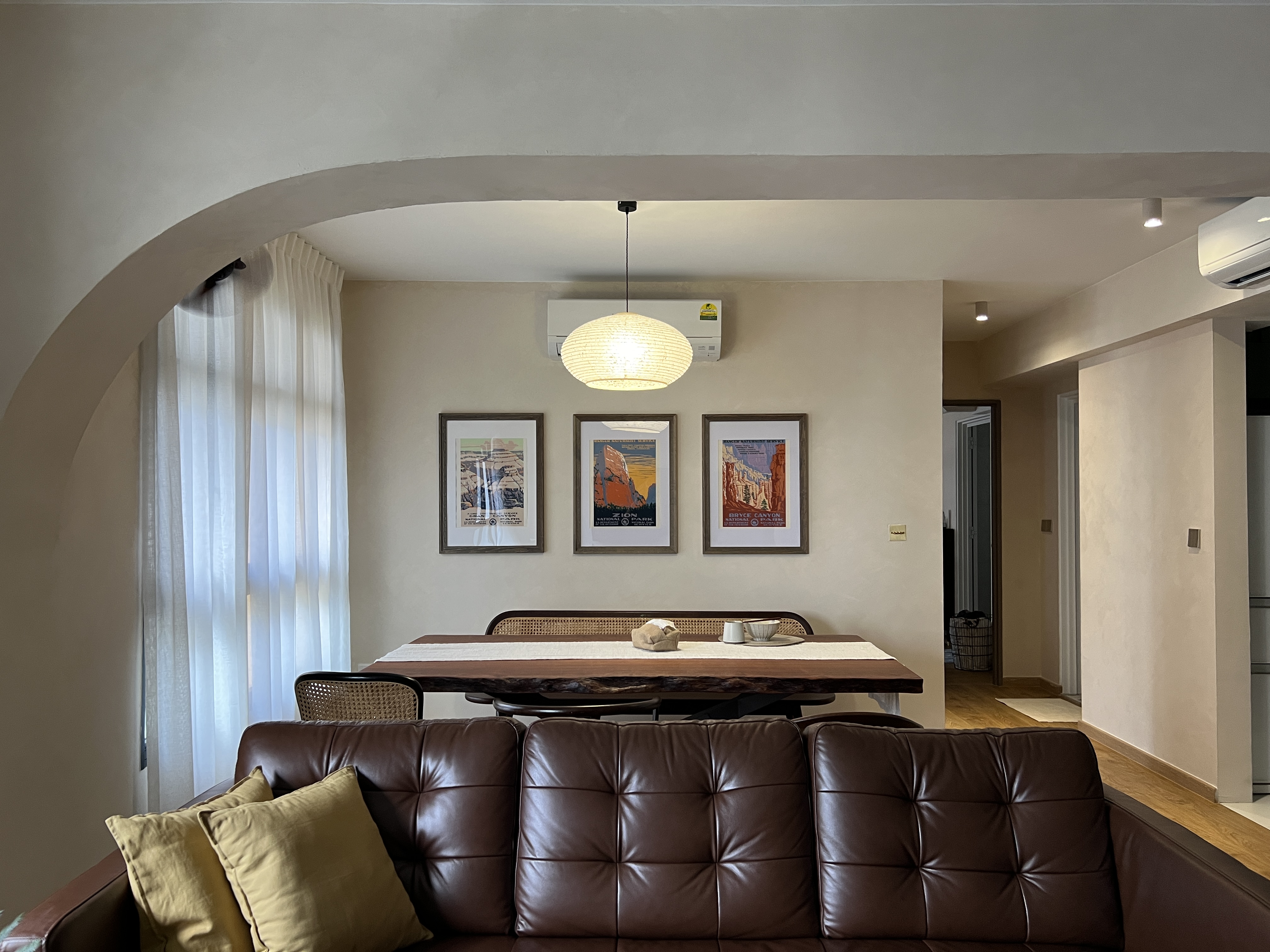 A communal space for sharing meals and having conversations - Cream-colored walls, elegant dining table, rustic wooden top