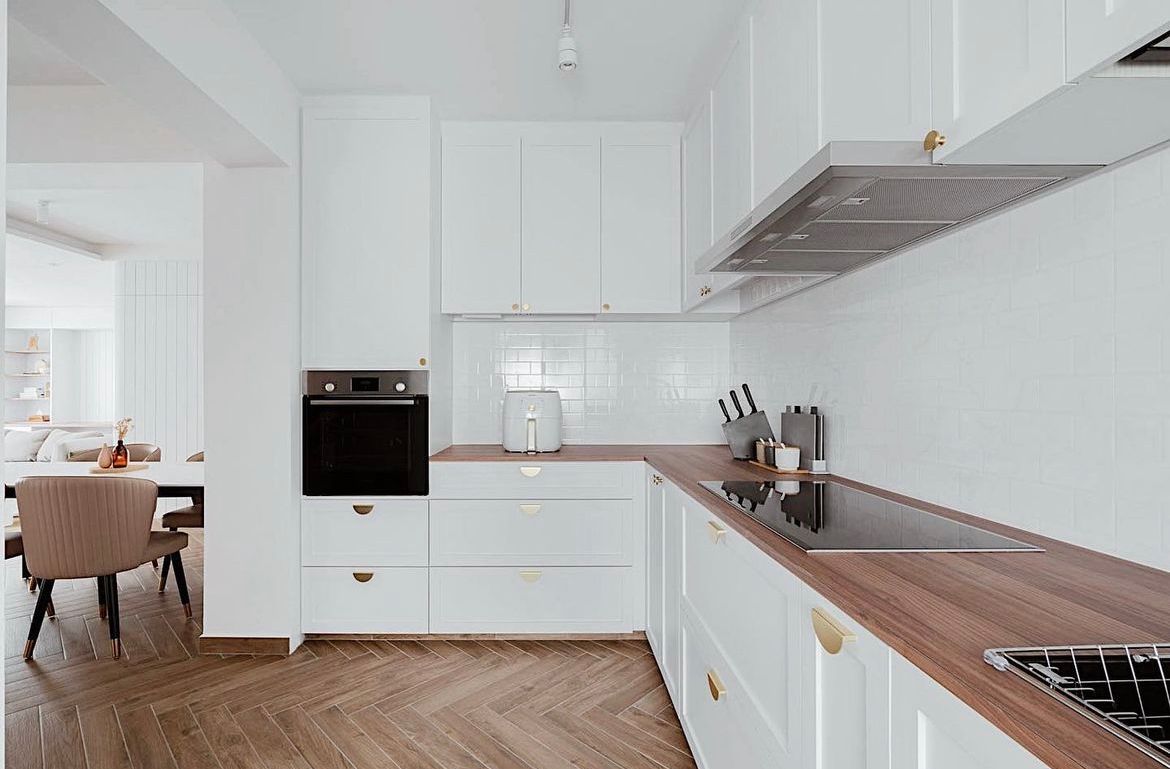 Opted for open concept kitchen with minimal design - White kitchen with wooden countertops, black oven, stainless steel range