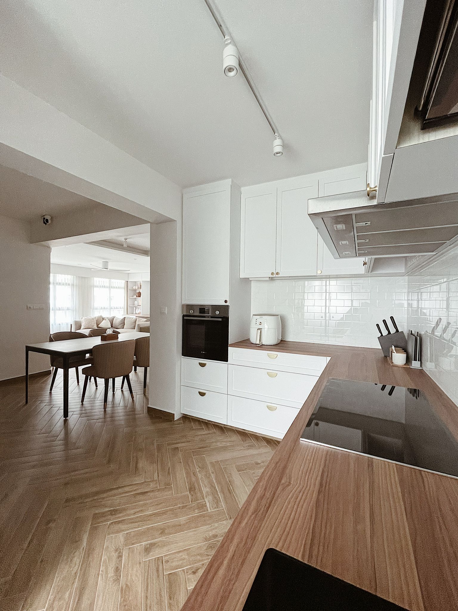 Opted for open concept kitchen with minimal design - Modern kitchen with white cabinetry, herringbone wooden flooring