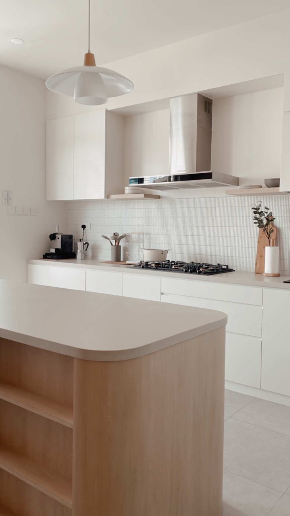 Our Minimalist Kitchen is a conversation starter - Modern minimalist kitchen, white cabinets, sleek pendant light, wooden