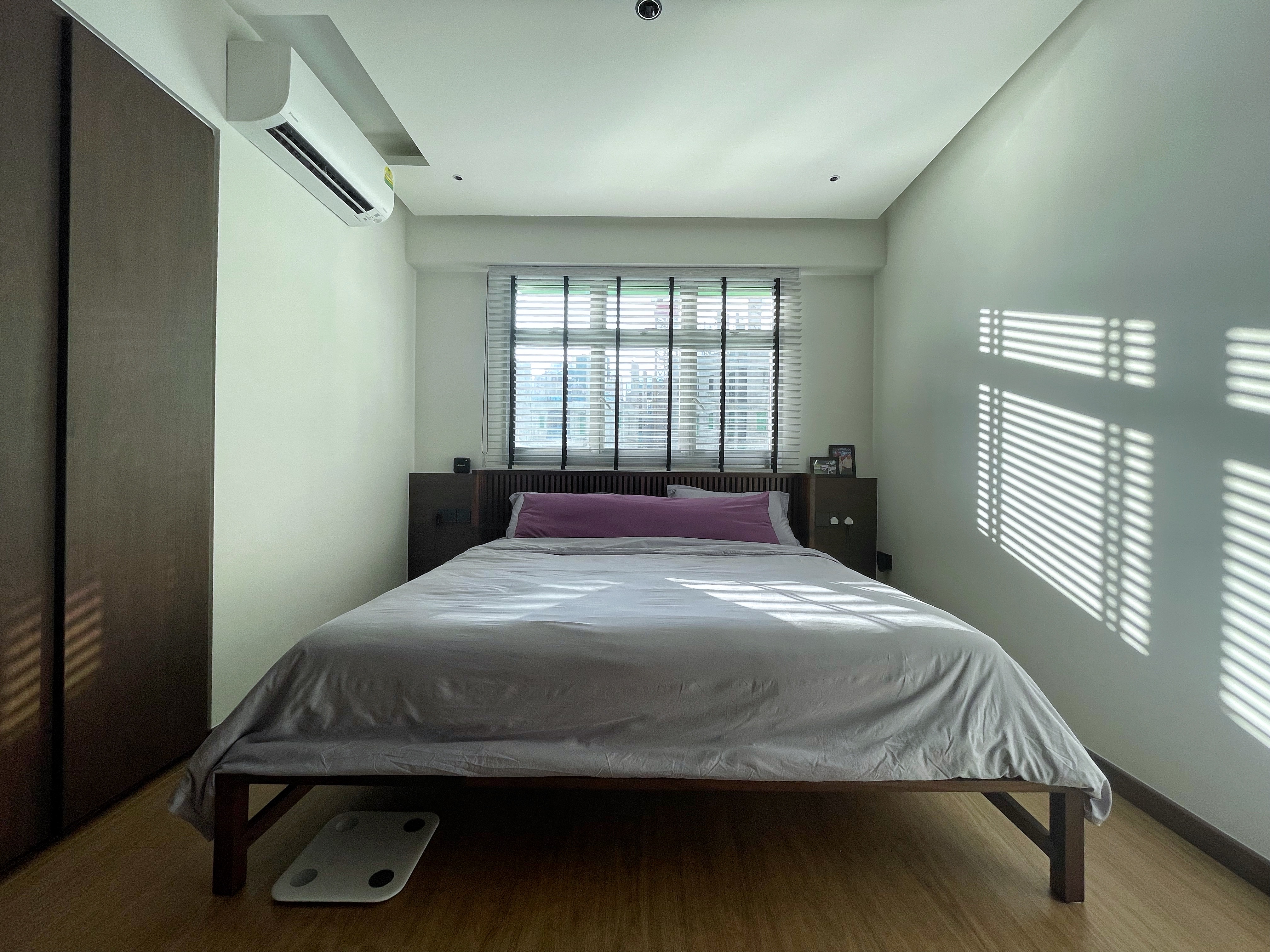 When sunlight hits, when darkness falls. - Modern bedroom with large bed, white and gray bedding, wooden floor, built-in