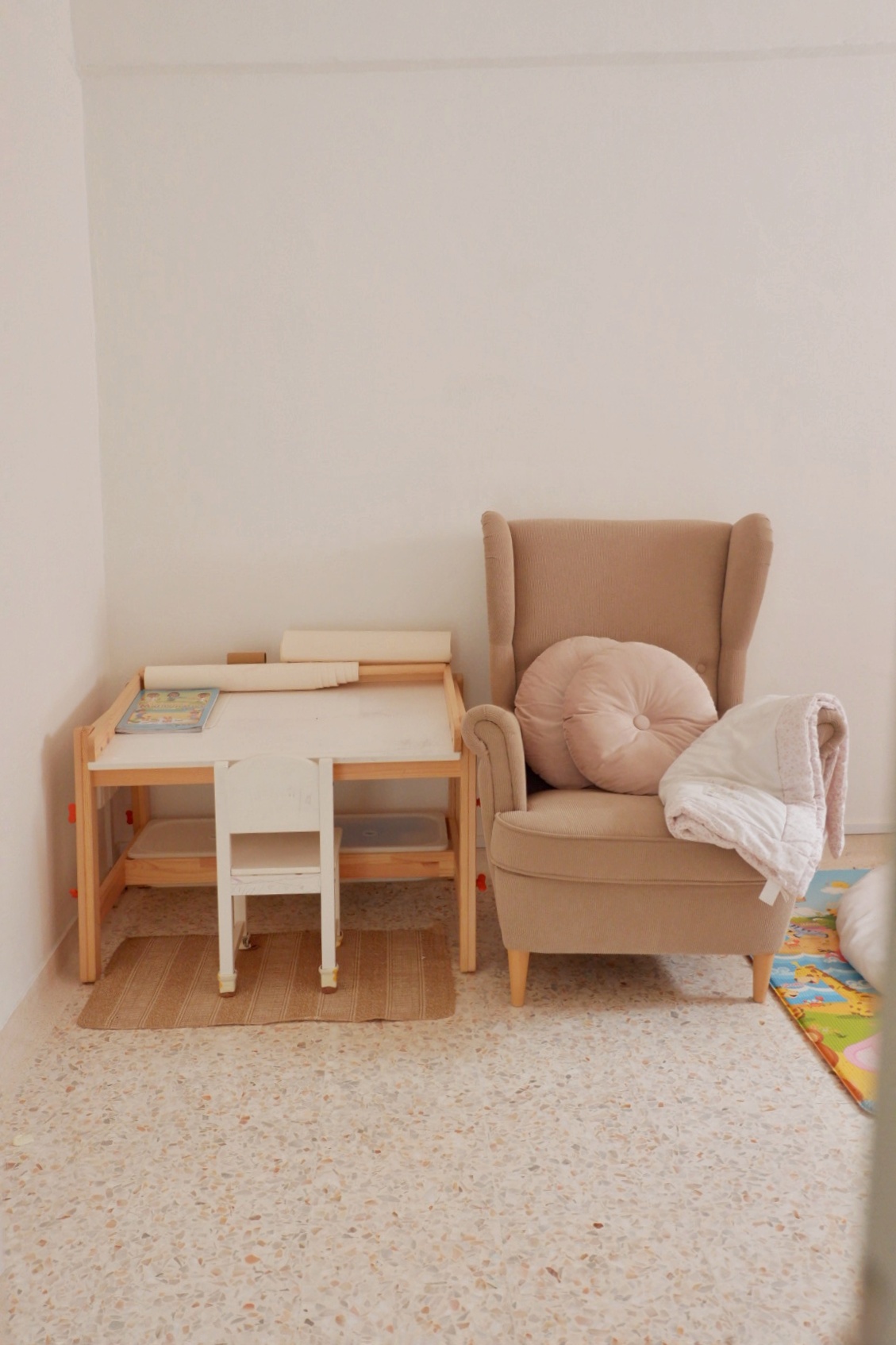 Scandinavian-inspired playroom - beauty is in the details - Wooden play table, beige armchair, soft cushions, colorful play