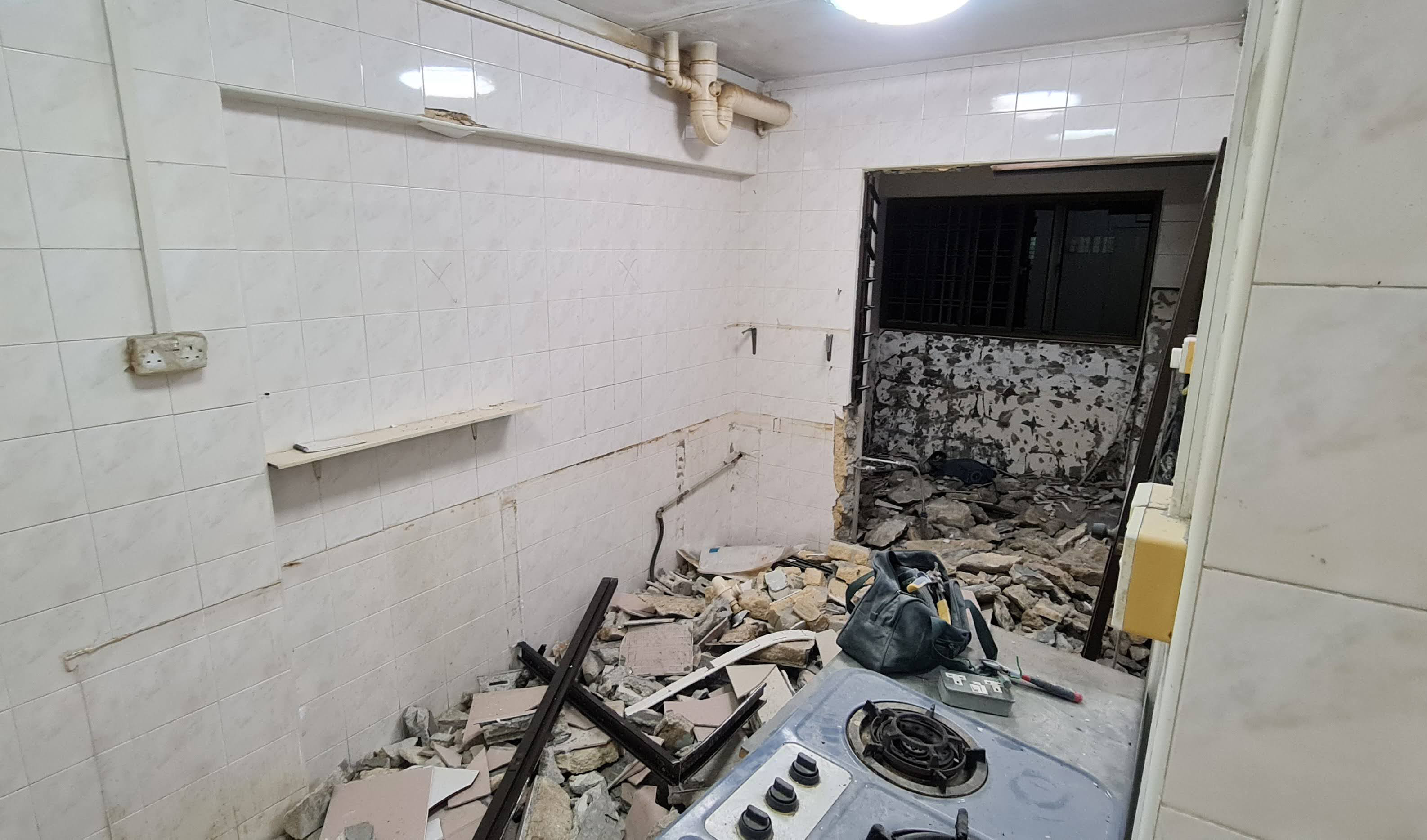 A Kitchen With Wooden Tones & Black Elements - Tiled room, debris, kitchen appliances, broken tiles, exposed pipes