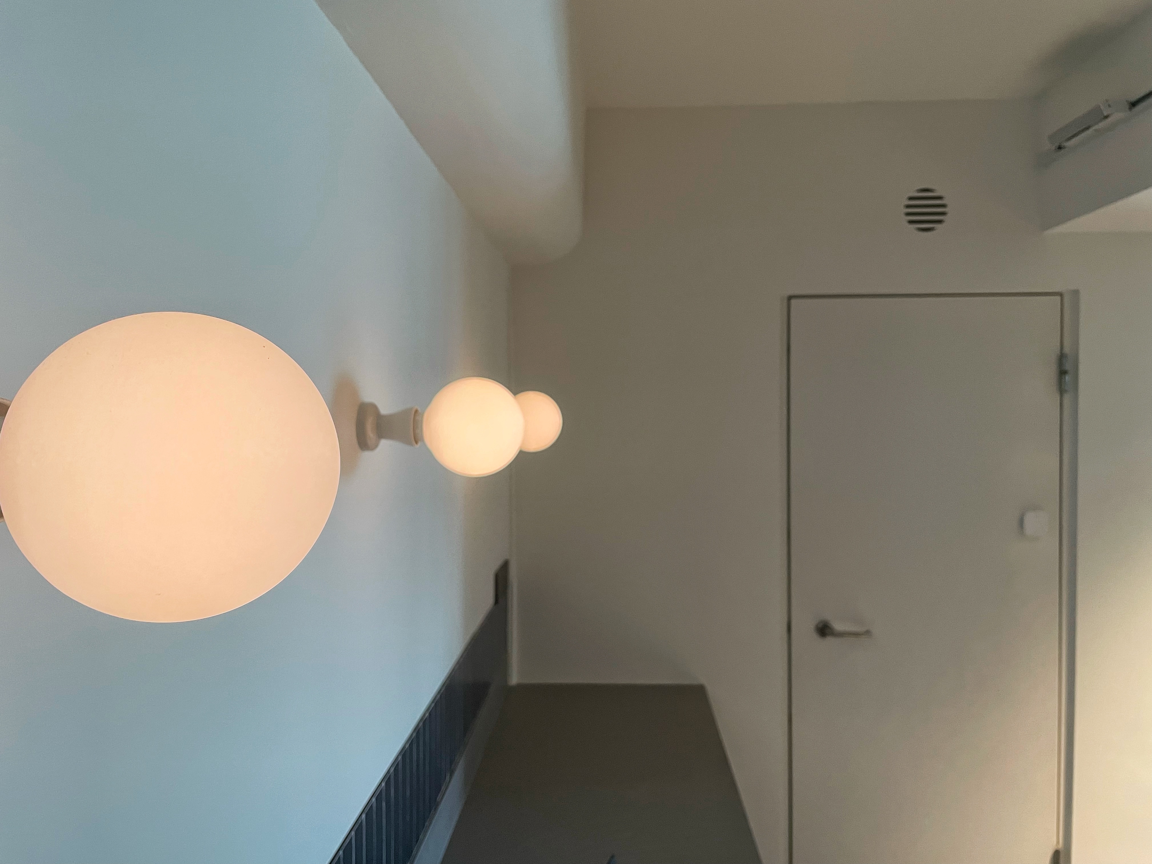 The unconventional  - Modern minimalist hallway, round wall sconces, soft ambient lighting, light fixture design, spherical