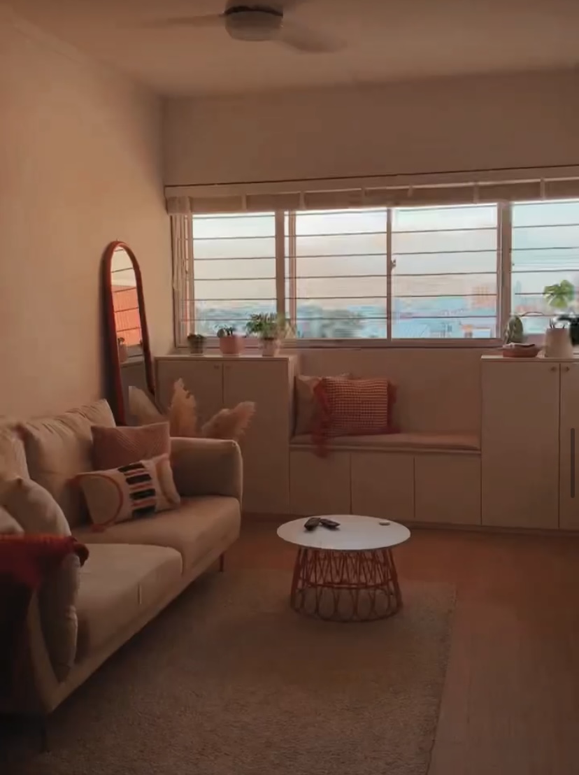 Our cozy, self-designed, odd-shaped home - Warmly lit living room, cozy sofa, beige cushions, decorative pillows, round