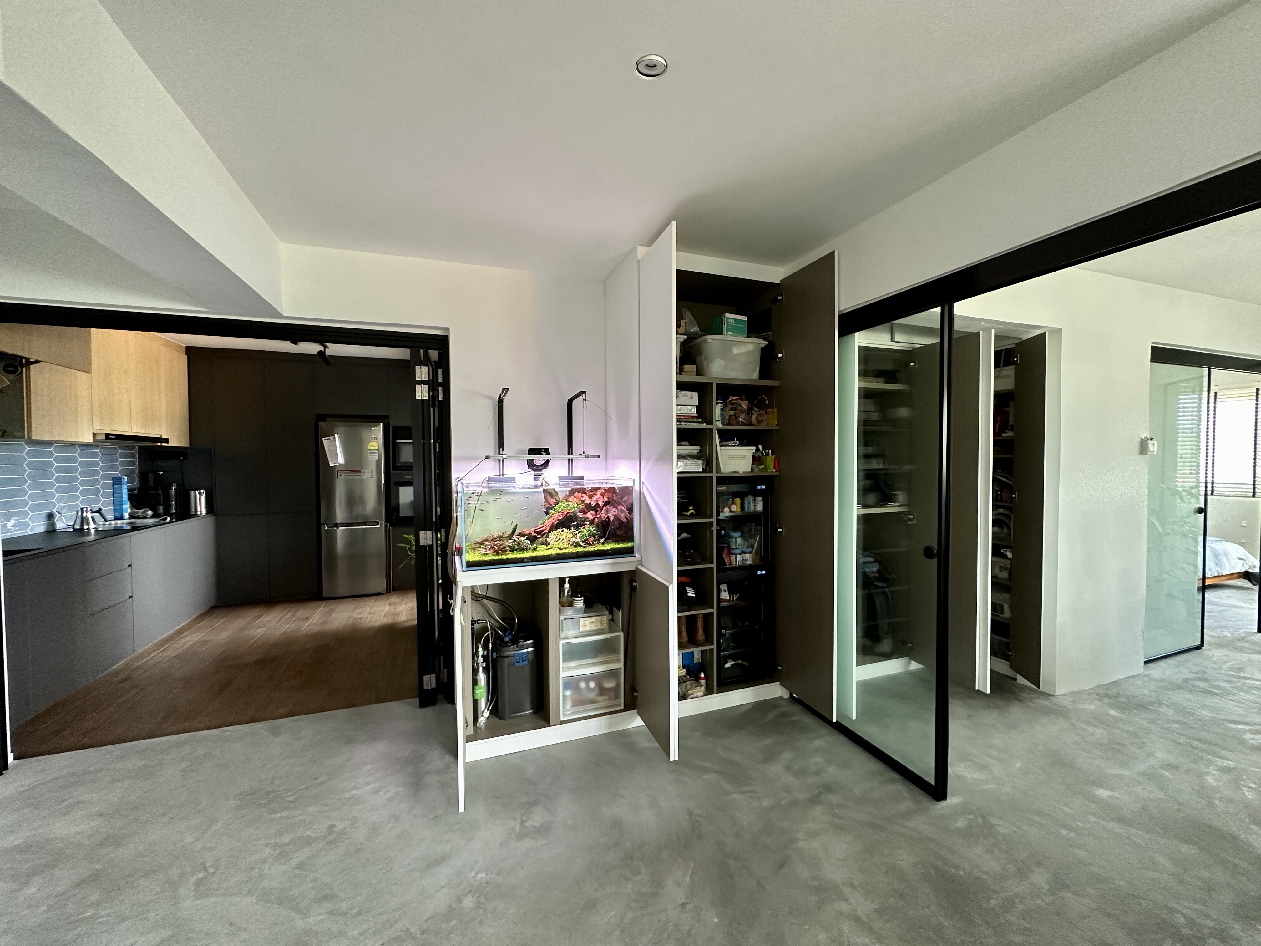 A central storage to keep the look neat - Modern kitchen with open cabinets, fish tank, grey flooring, stainless steel