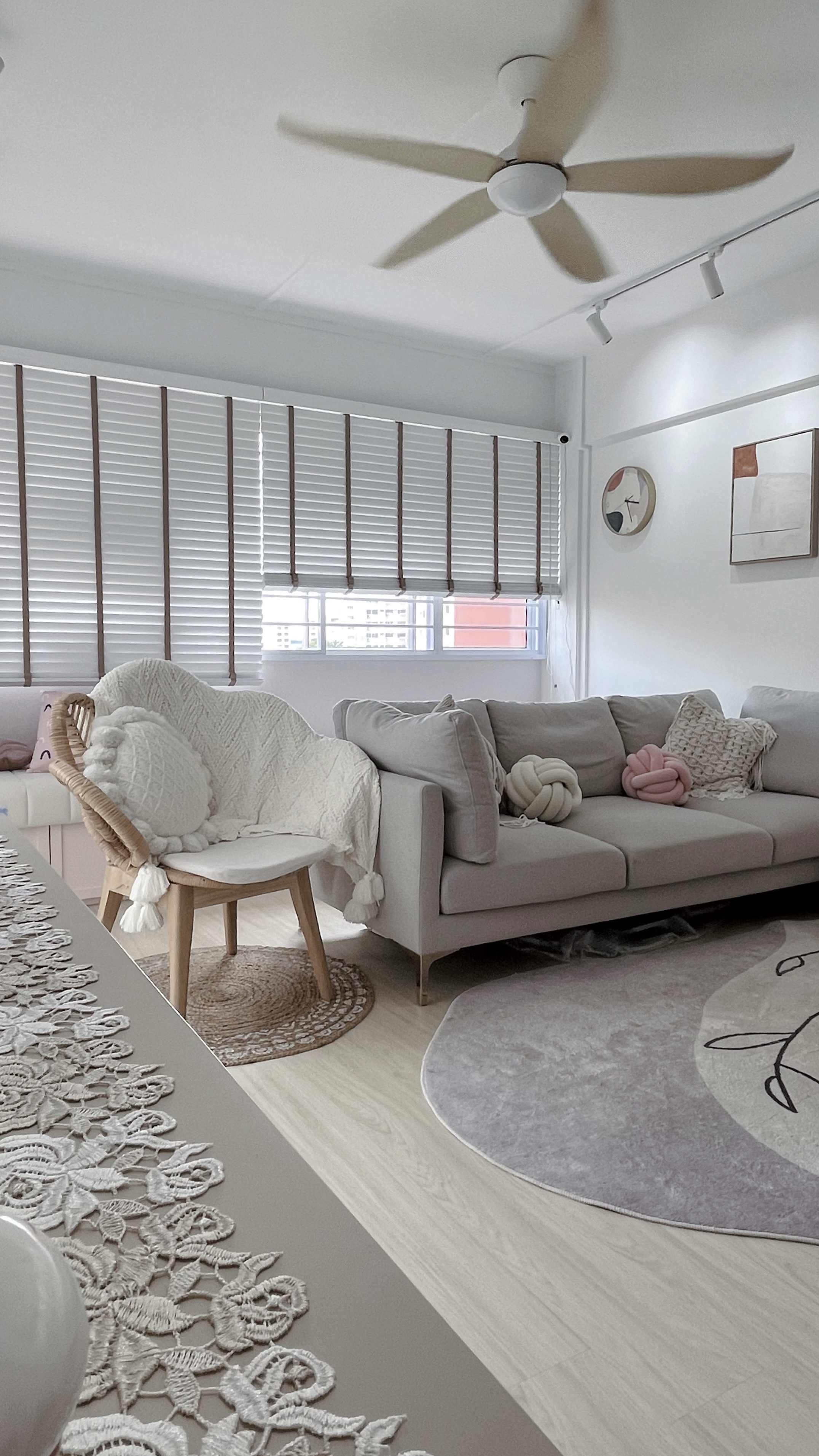 Living Room - the reset corner - Cream sofa, white armchair, light gray rug, wooden floor, sheer curtains, abstract wall art