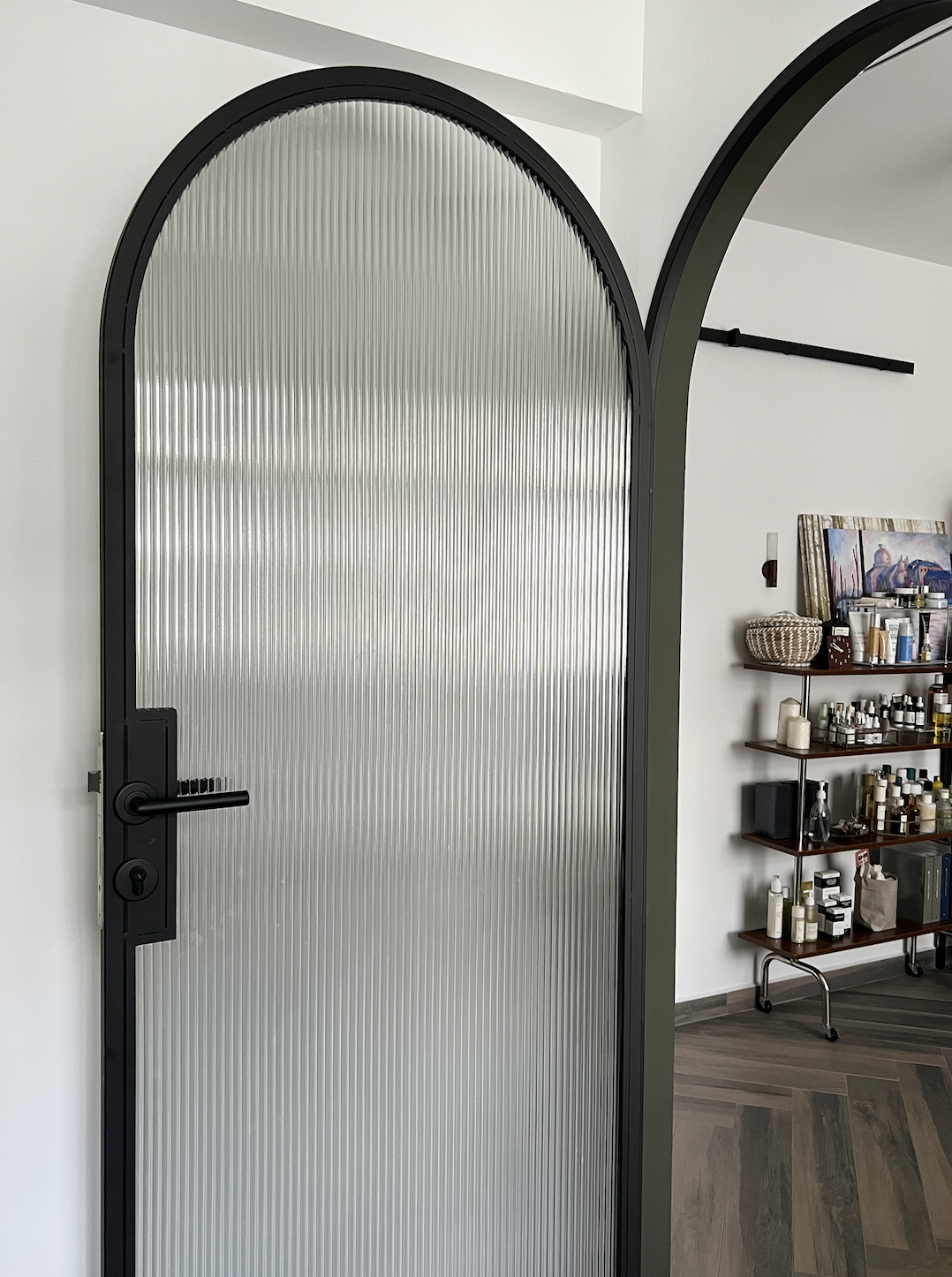 Mid-century modern master bedroom with walk in wardrobe in 4 room BTO - Arched door with vertical ribbed design, sleek black