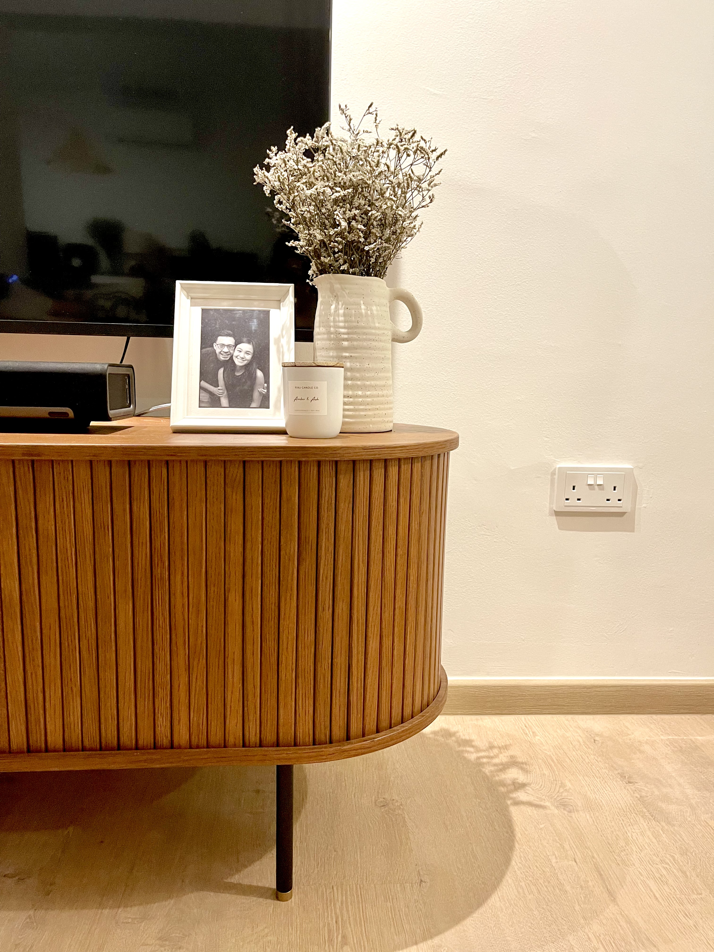 Minimal carpentry and all about styling your living room. - Wooden side table, black television, framed photo, white vase