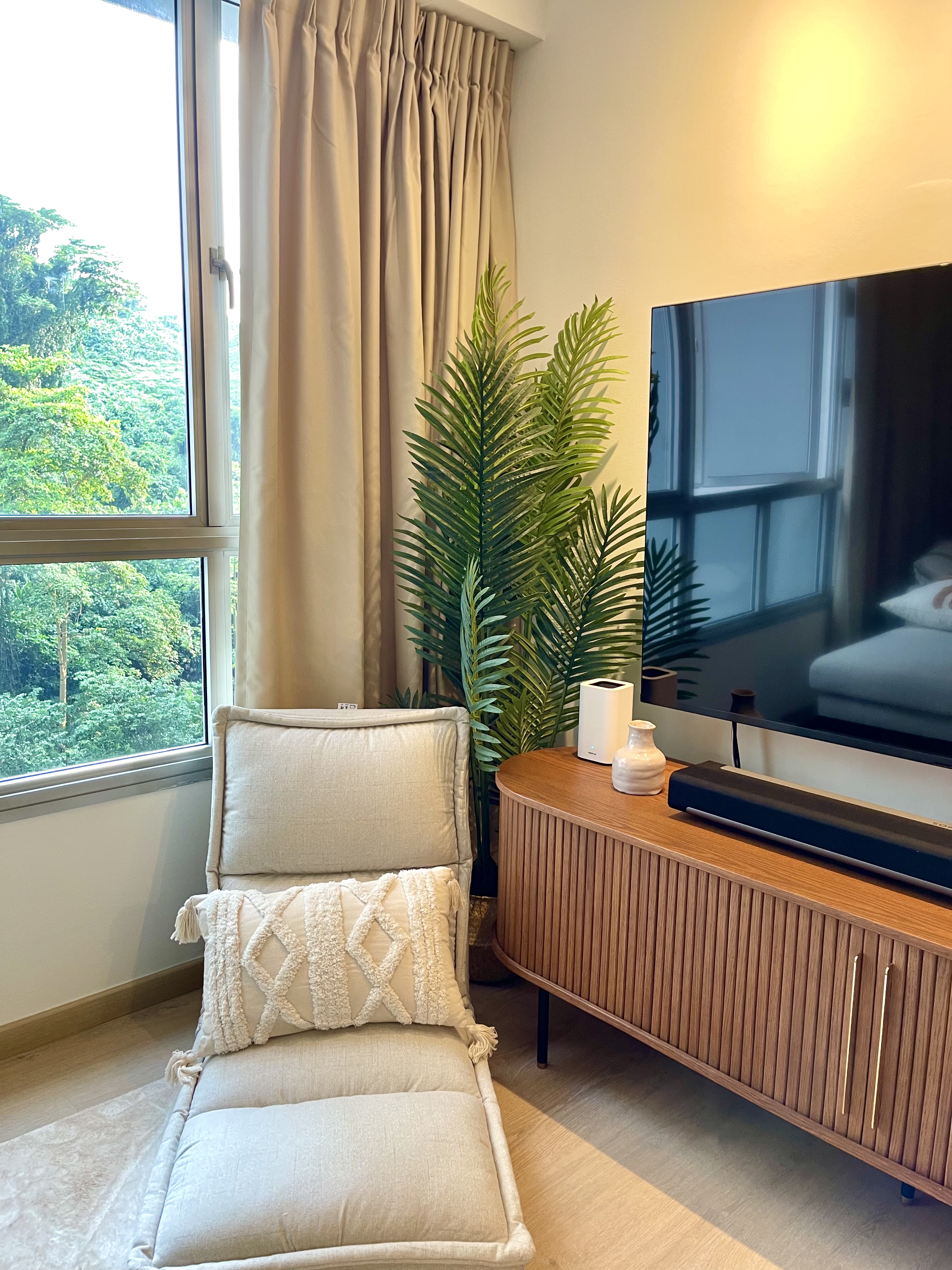 Minimal carpentry and all about styling your living room. - Large window with beige curtains, lush green foliage outside