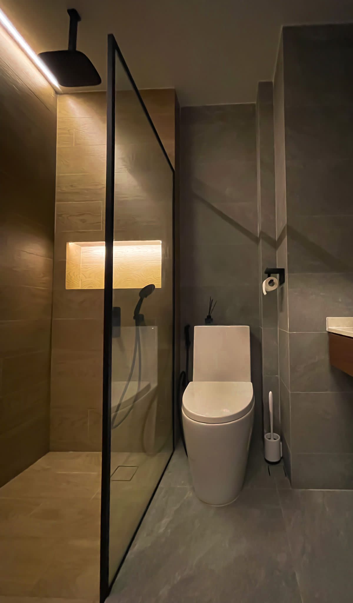 Minimalistic bedroom with a hidden closet and bathroom - Modern bathroom with sleek design, beige and gray tiles, glass