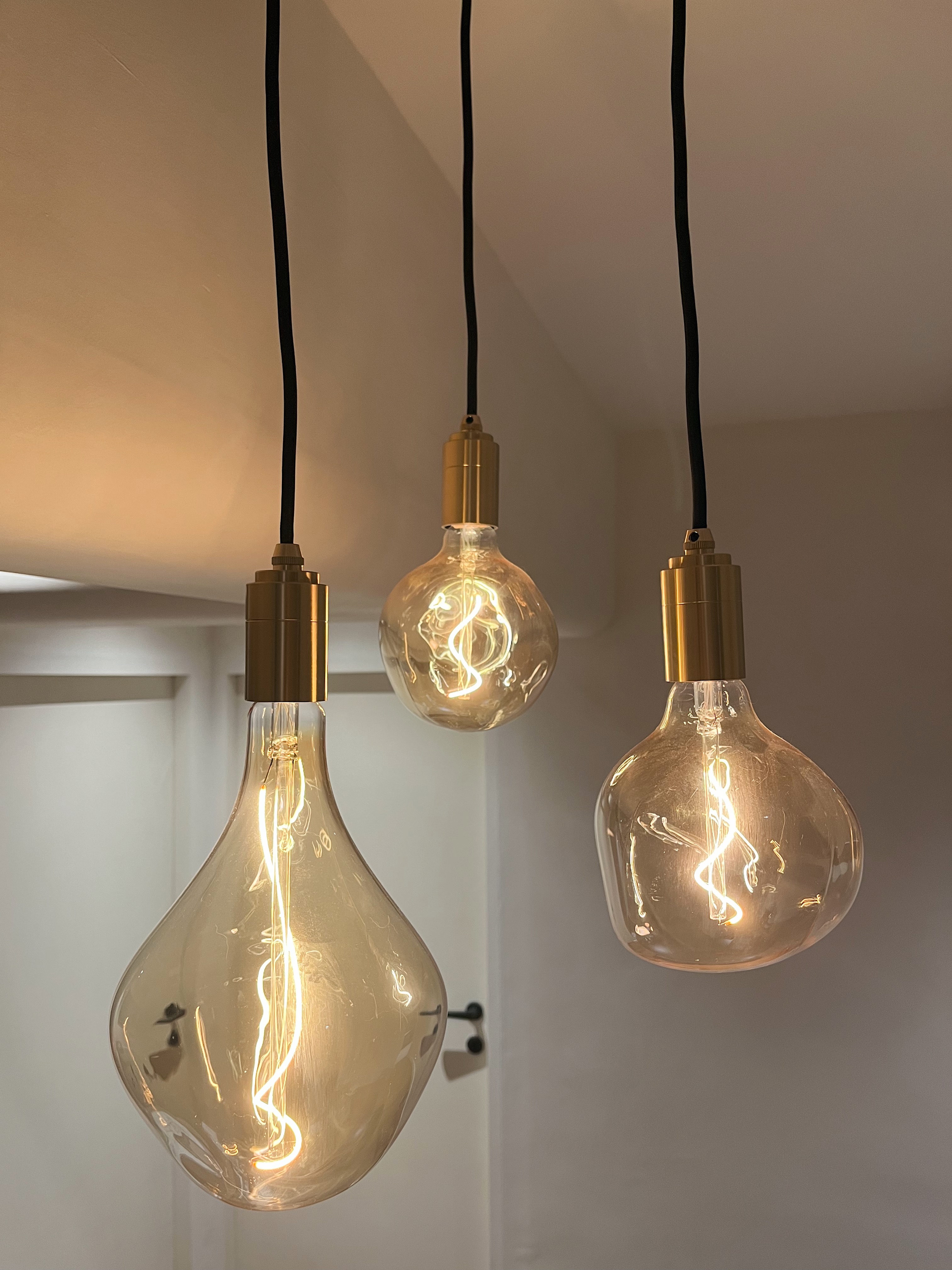 Purposefully Designed Dining Spaces for Dining & Admiring  - Modern pendant light fixture, sleek design, vintage-style bulbs