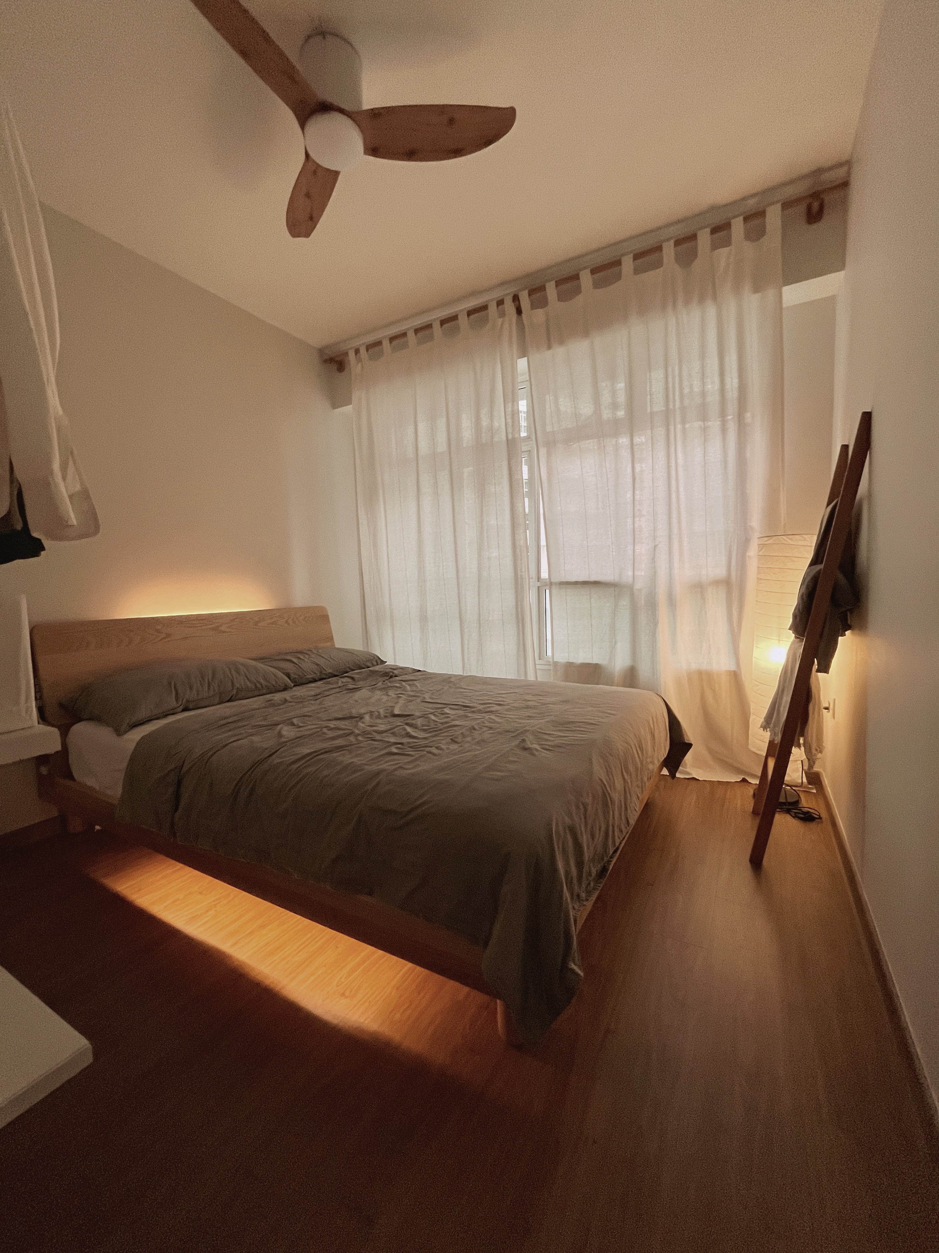 Comfort without clutter - Lagom in the bedroom - Wooden ceiling fan, beige walls, wooden bed frame, gray bedding, white