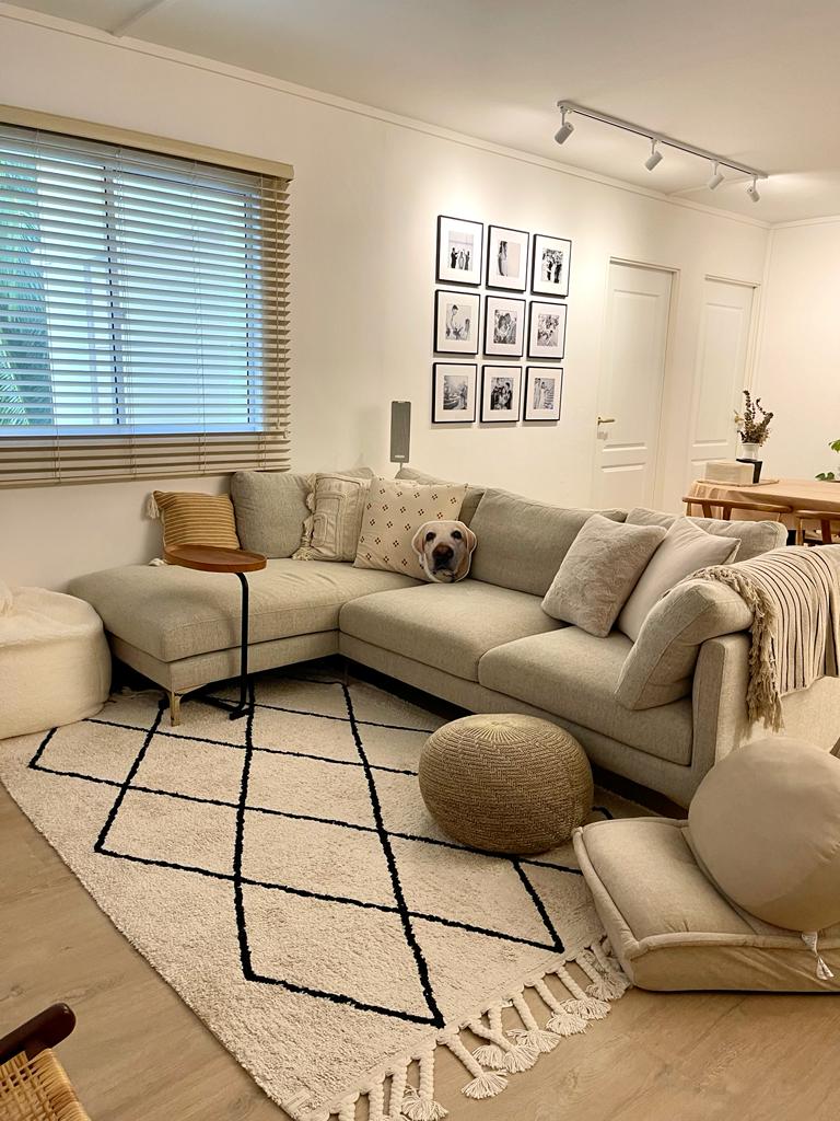 A tour in our Living Room - Cream-colored sectional sofa, beige cushions, black and white geometric rug, wooden side table
