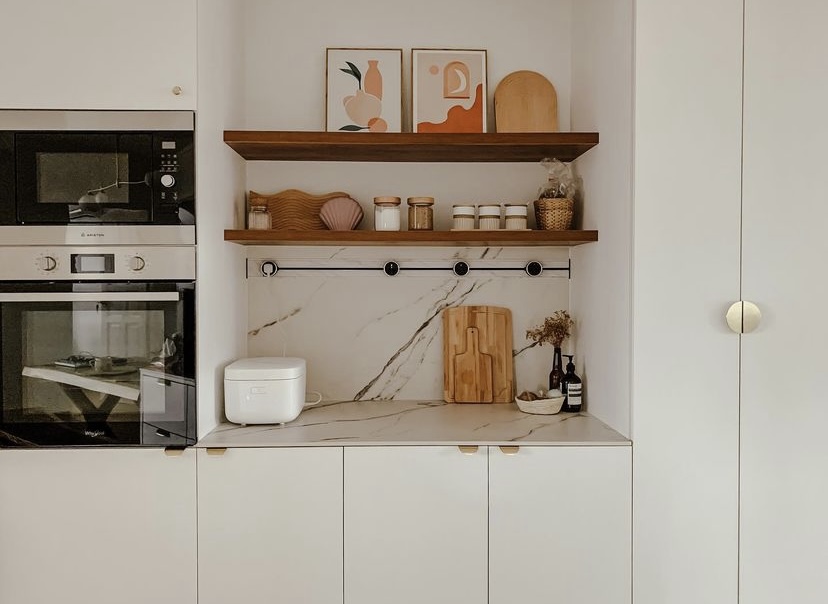 Our open-concept but practical kitchen - White kitchen cabinetry, marble countertop, modern appliances, wooden shelves