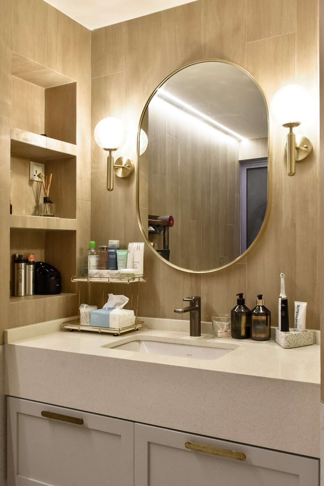 Bathroom Bliss: the Perfect Relaxation Space - Bathroom vanity, modern design, beige walls, gold fixtures, oval mirror