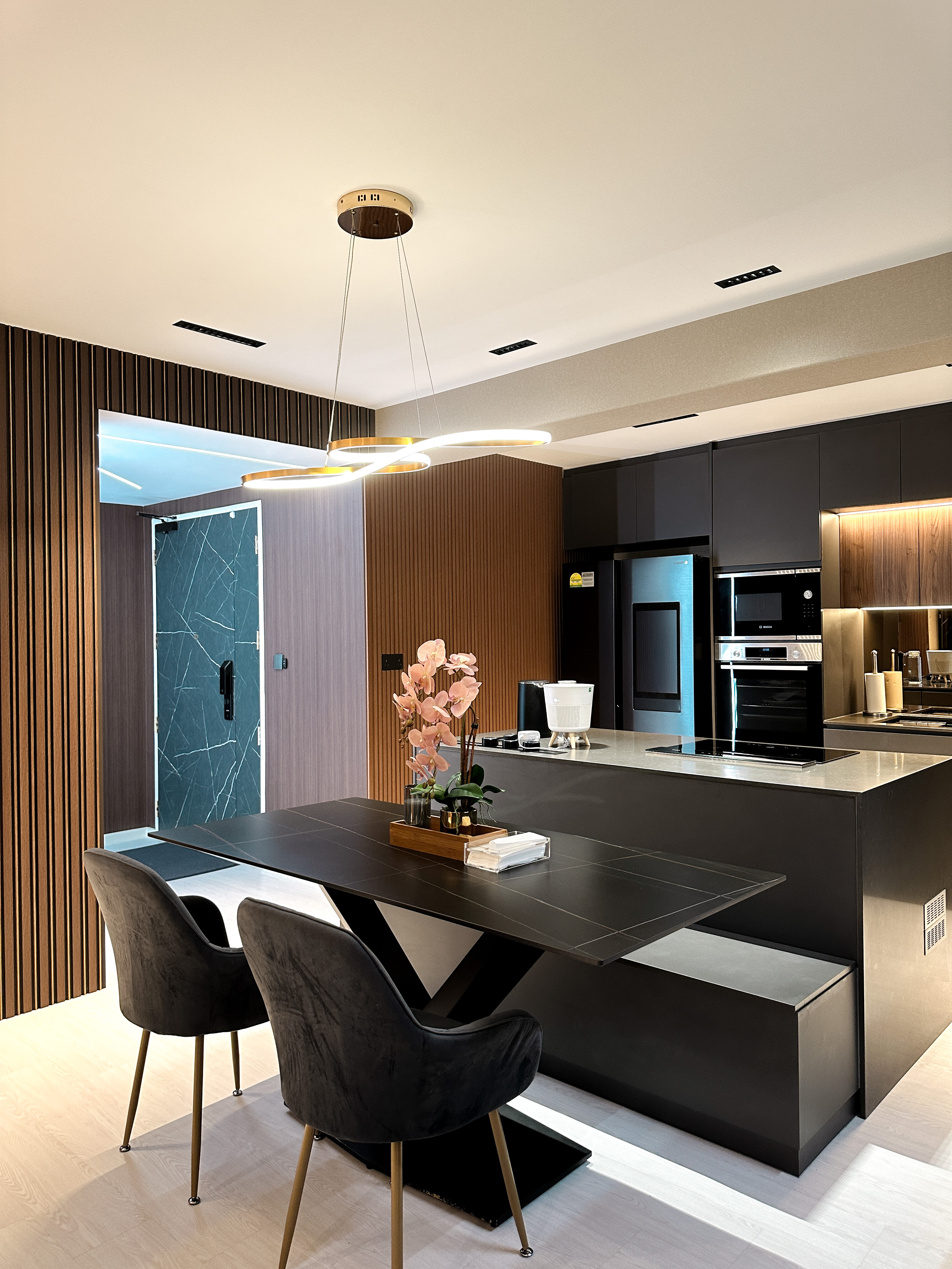 Hotel-like Luxe in a Home - Modern kitchen with sleek design, contemporary furniture, black countertops, stainless steel