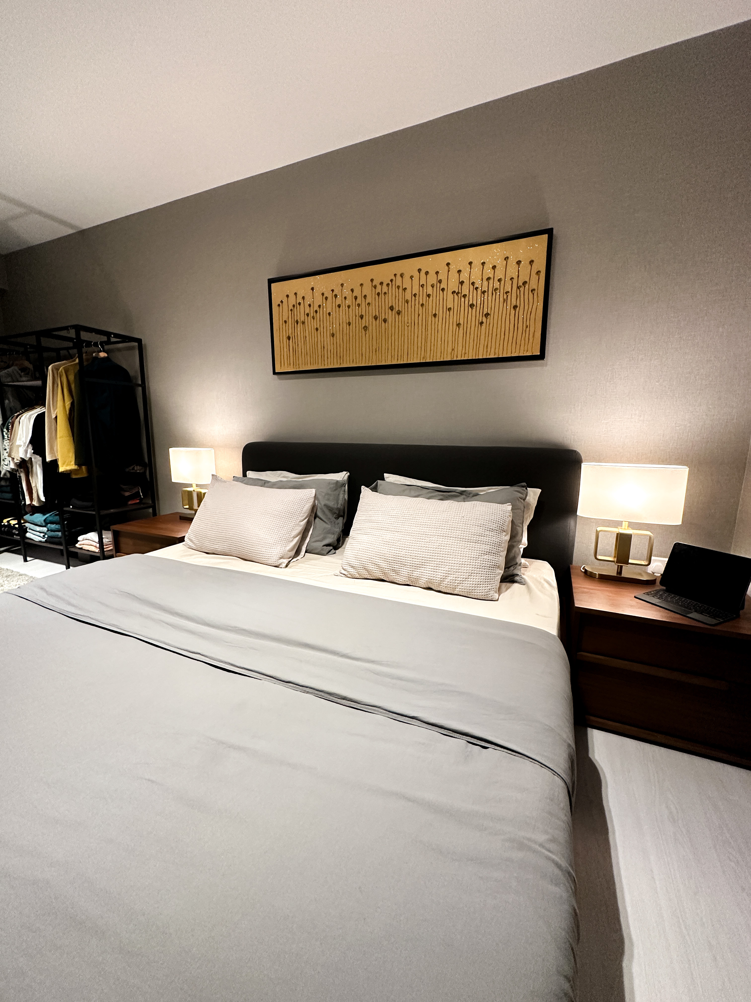 Hotel-like Luxe in a Home - Modern bedroom with neatly made bed, gray bedding, soft lighting, minimalist decor, black