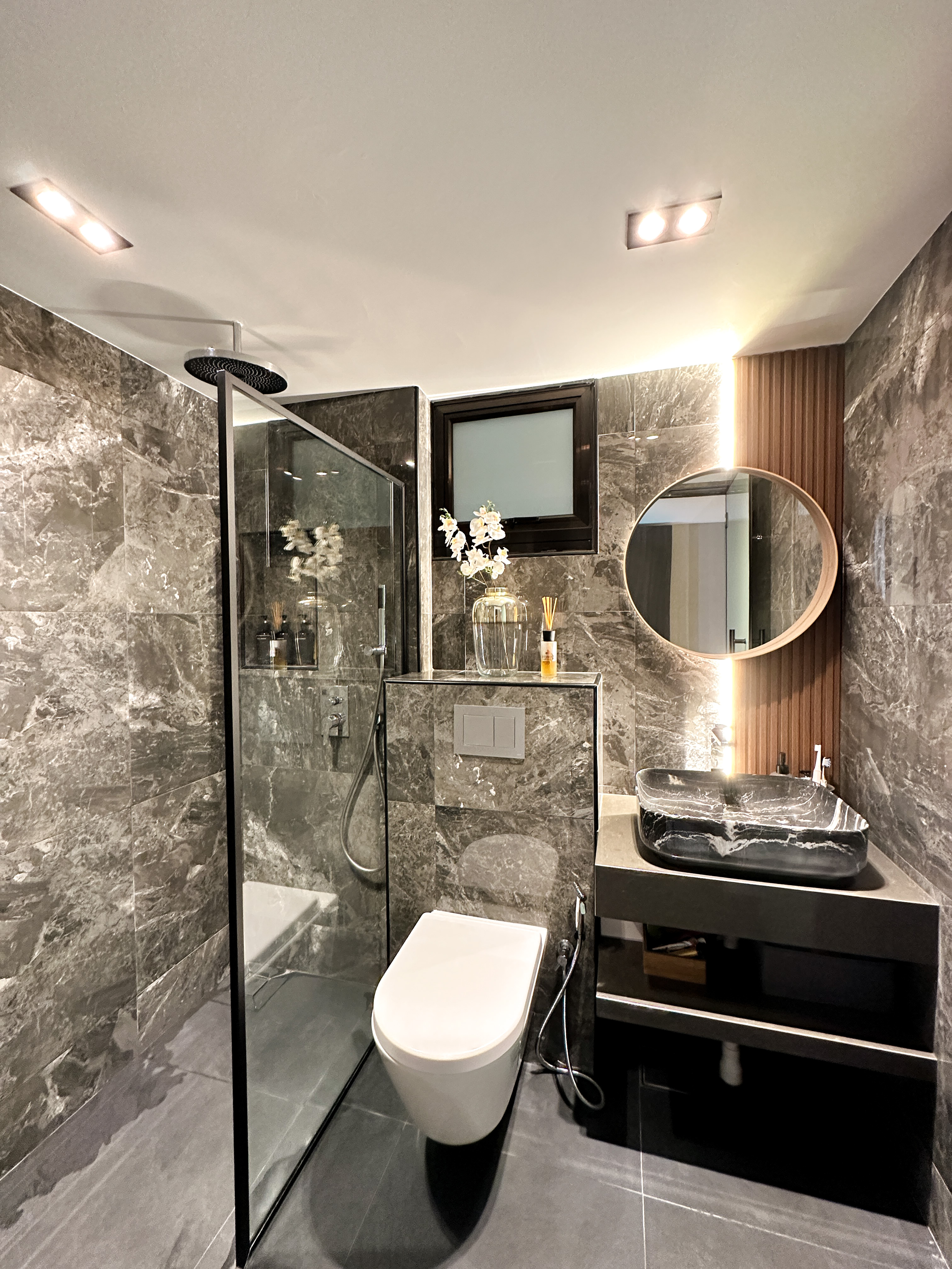 Hotel-like Luxe in a Home - Modern bathroom with sleek design, marble tiles, glass shower enclosure, built-in sink, floating