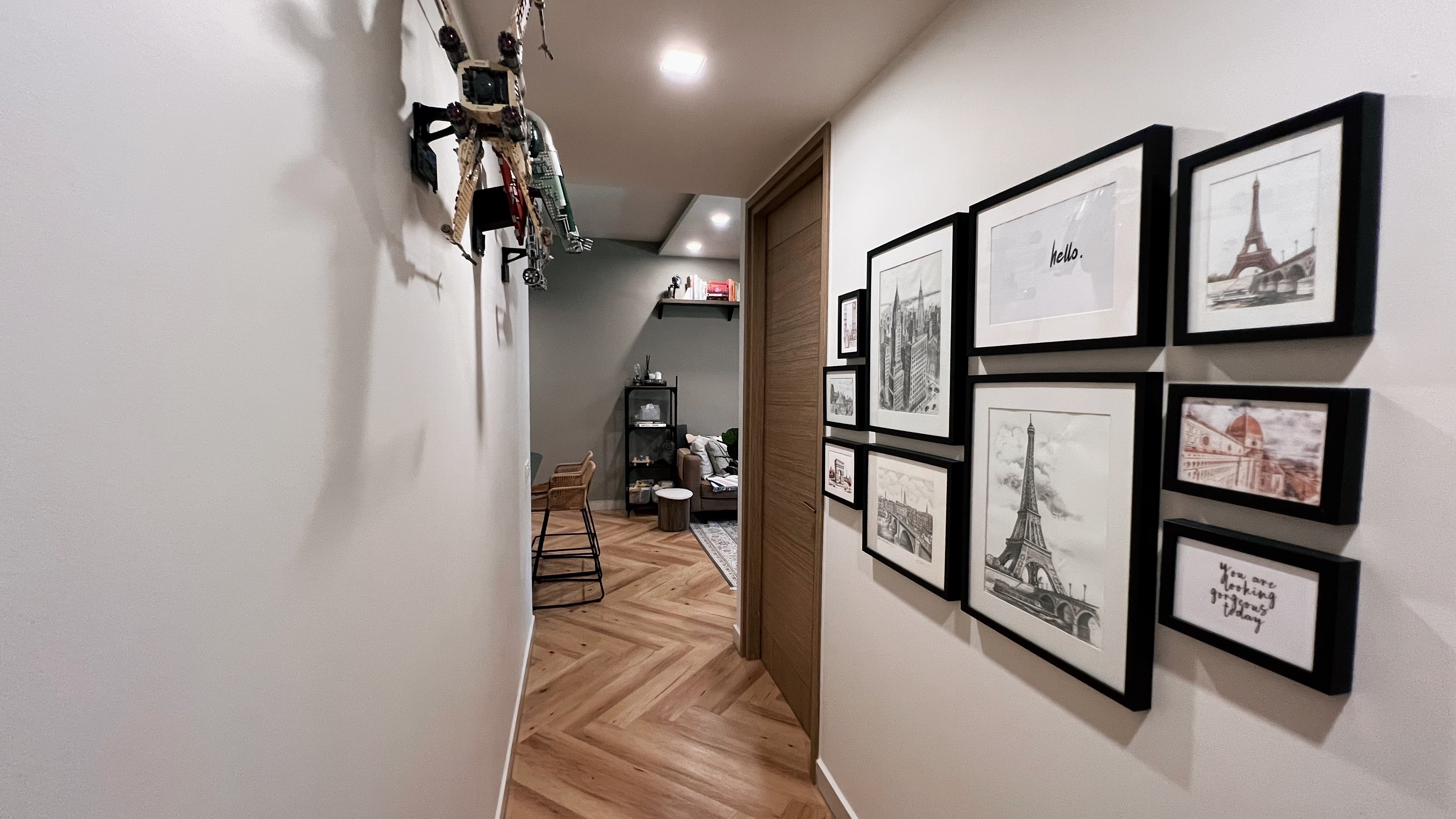 1260sqft ground floor unit with a garden view! - Hanging robot model, wooden herringbone floor, modern living room, framed