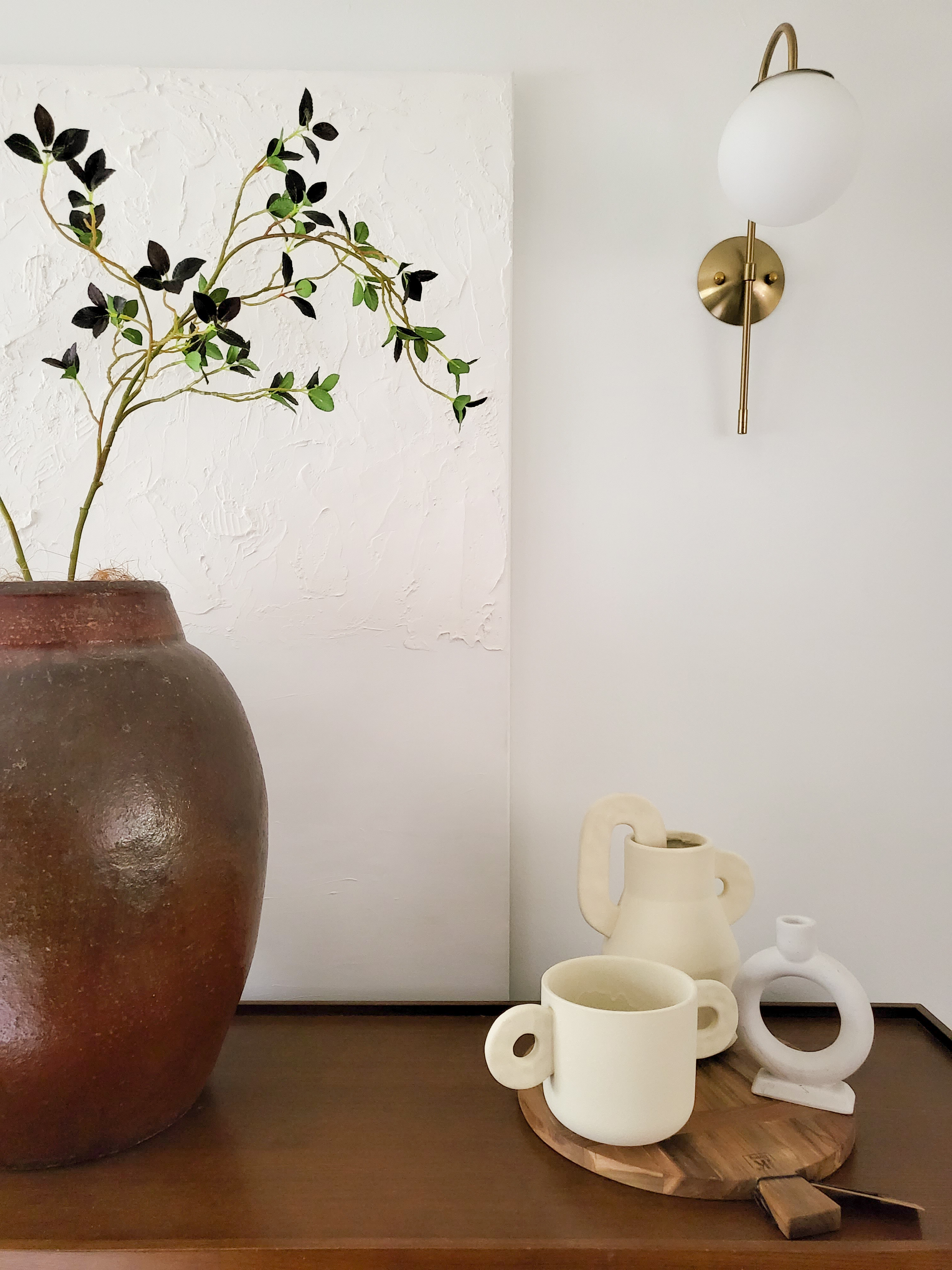 Quaint and Charming Dining Spaces  - vibrant green leaves, rustic brown vase, modern wall art, abstract plant design