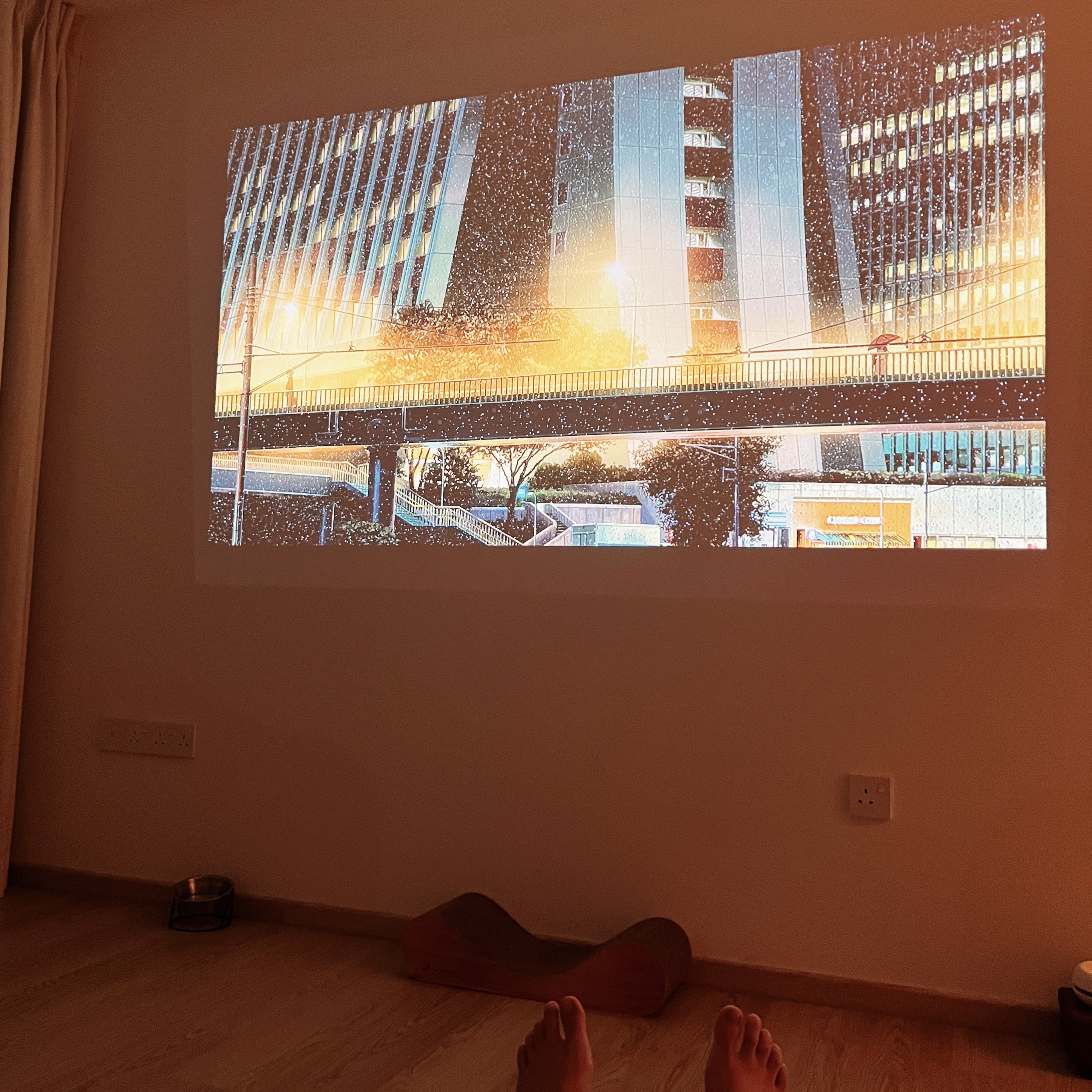 Projecting Tranquillity: A TV-Free Home - Indoor projection on wall, displaying cityscape with falling snowflakes, Warm