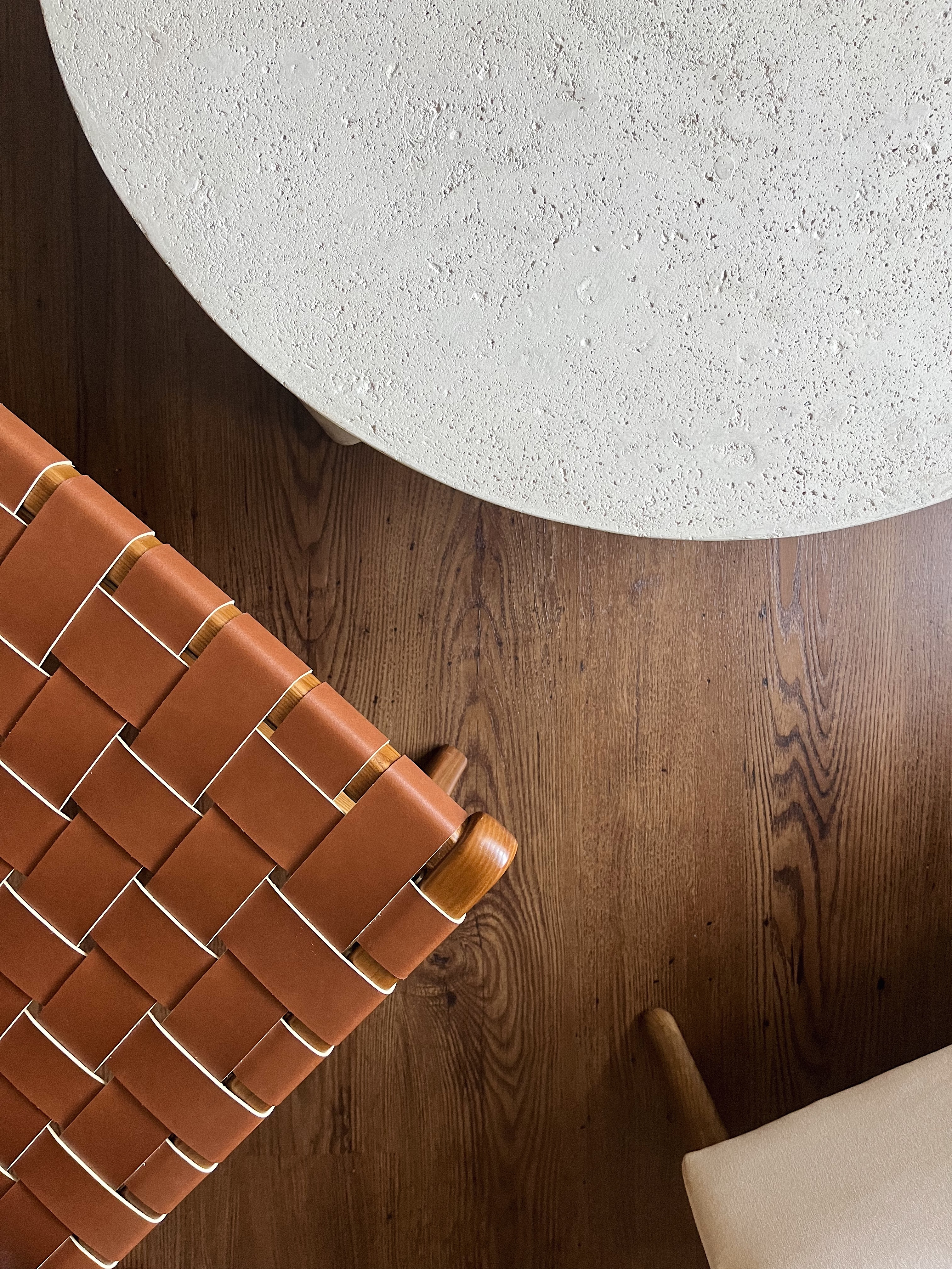 Spicing Up Small Living Spaces  - Cobblestone table, textured surface, wooden floor, brown woven chair, natural wood grain