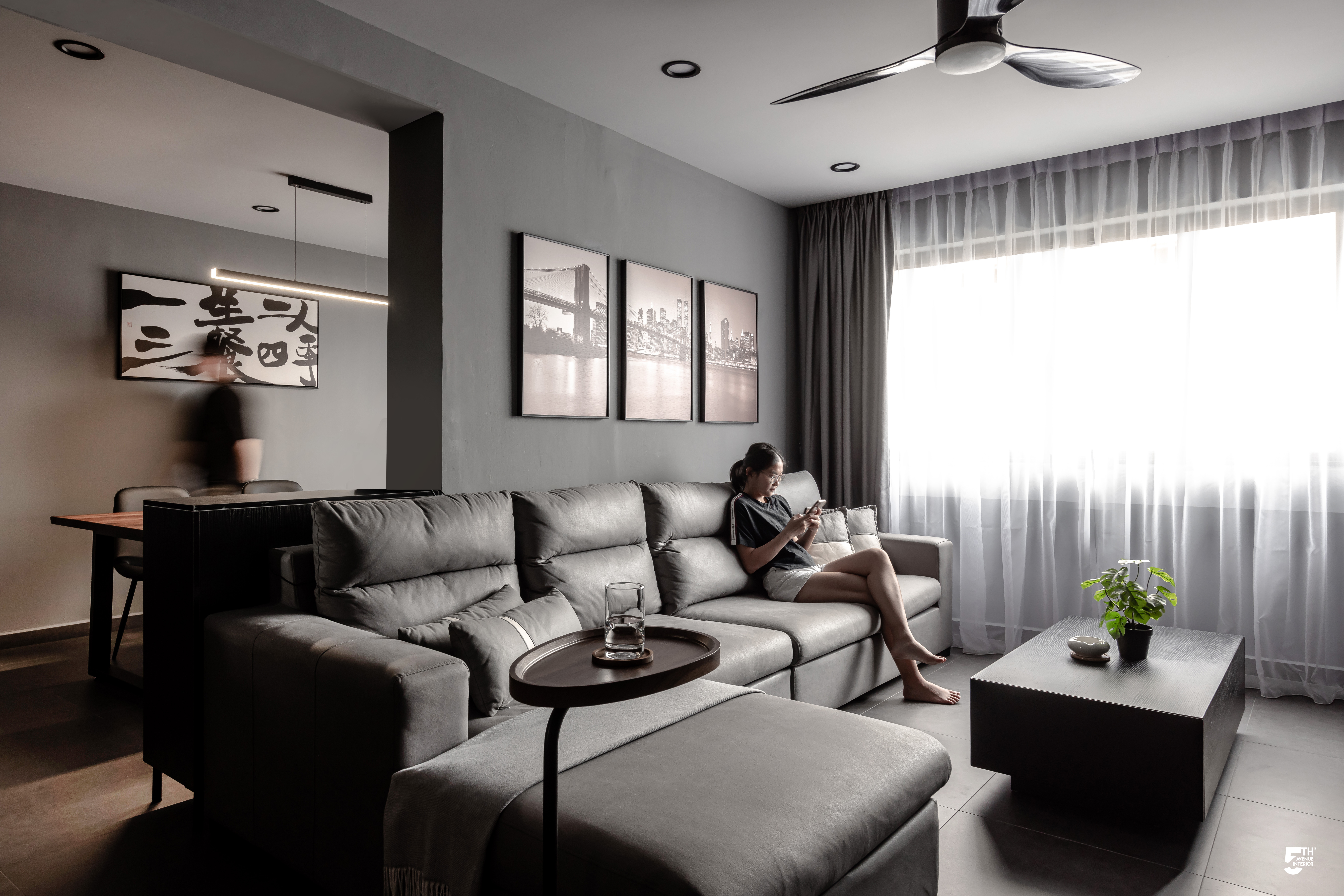 Living Room in Grey - Modern living room with gray walls, minimalist design, large window with sheer curtains, ceiling fan