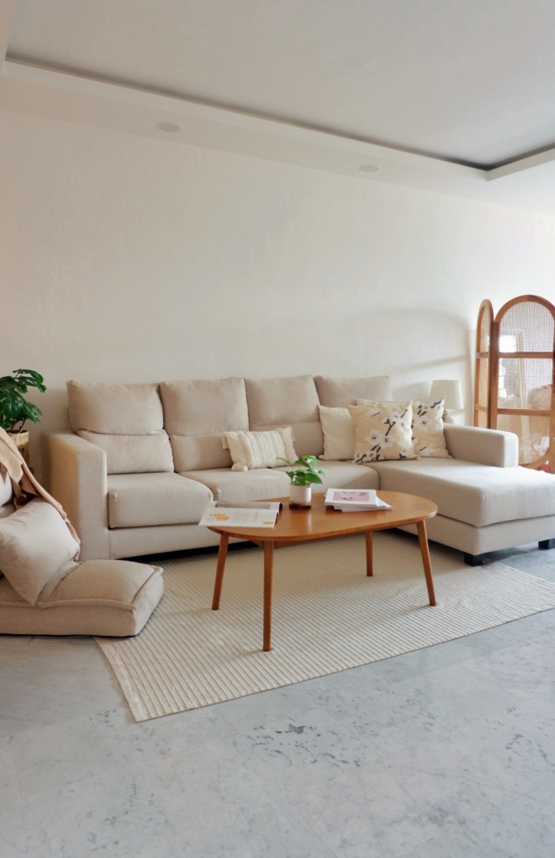 Minimalist Living Room  - Cream-colored sectional sofa, minimalist decor, light beige cushions, wooden coffee table, modern