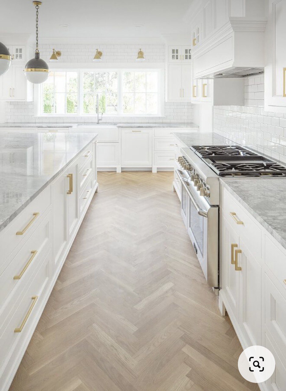 Our Farmhouse Kitchen Dreams - White kitchen with herringbone wood flooring, stainless steel appliances, large windows, light