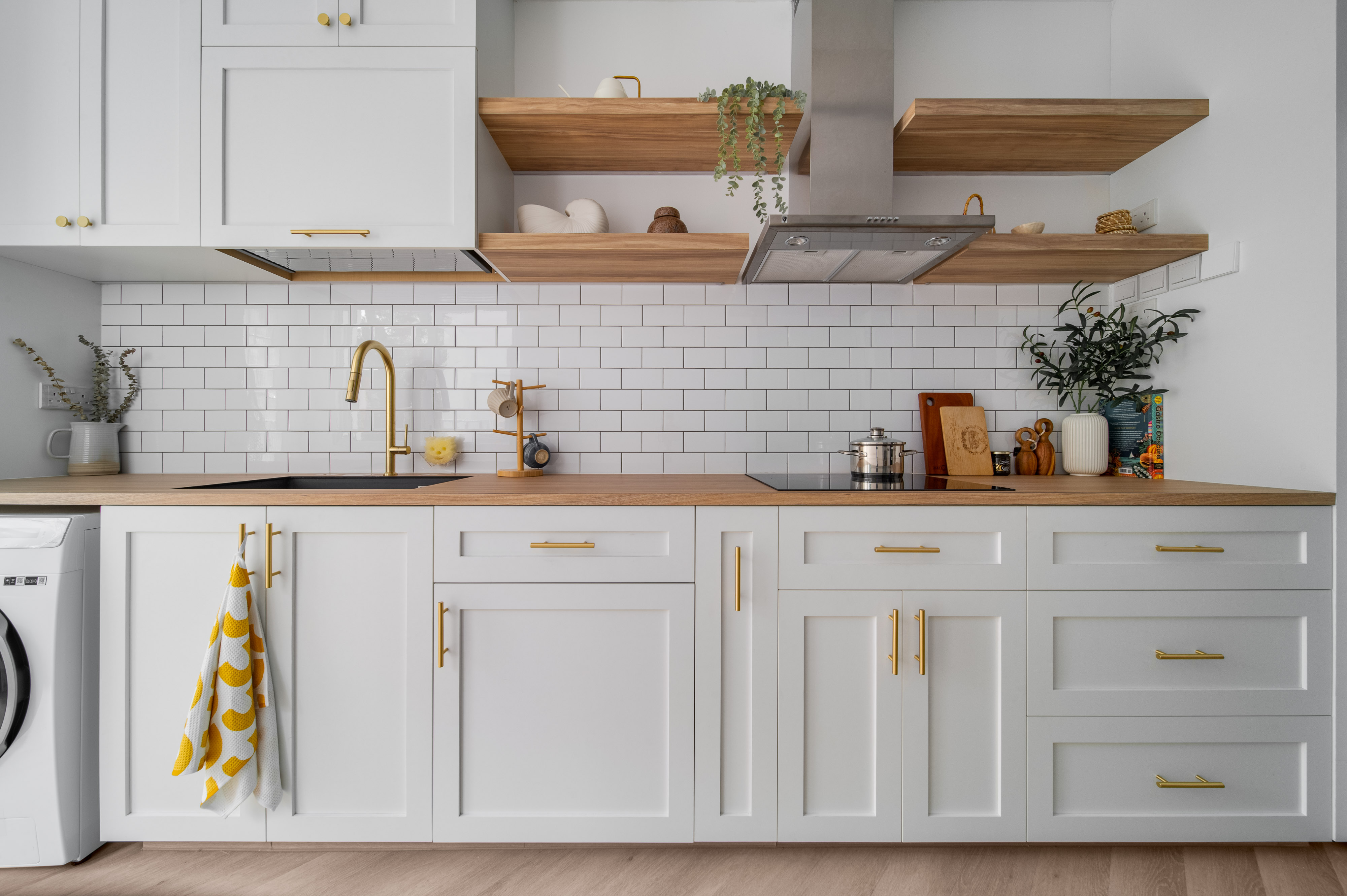Our Farmhouse Kitchen Dreams - White kitchen cabinetry with gold handles, wooden shelves, white tiled backsplash, stainless