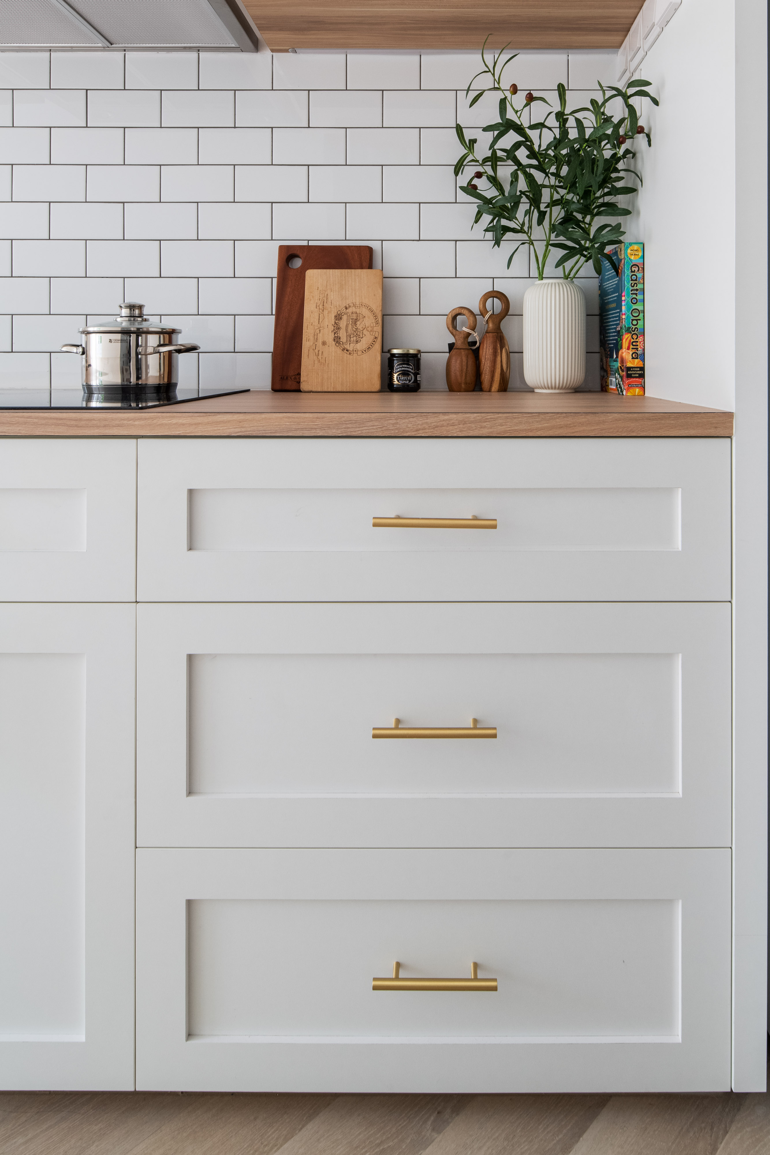 Our Farmhouse Kitchen Dreams - White kitchen countertop, modern cabinets, gold handles, stainless steel pot, wooden cutting